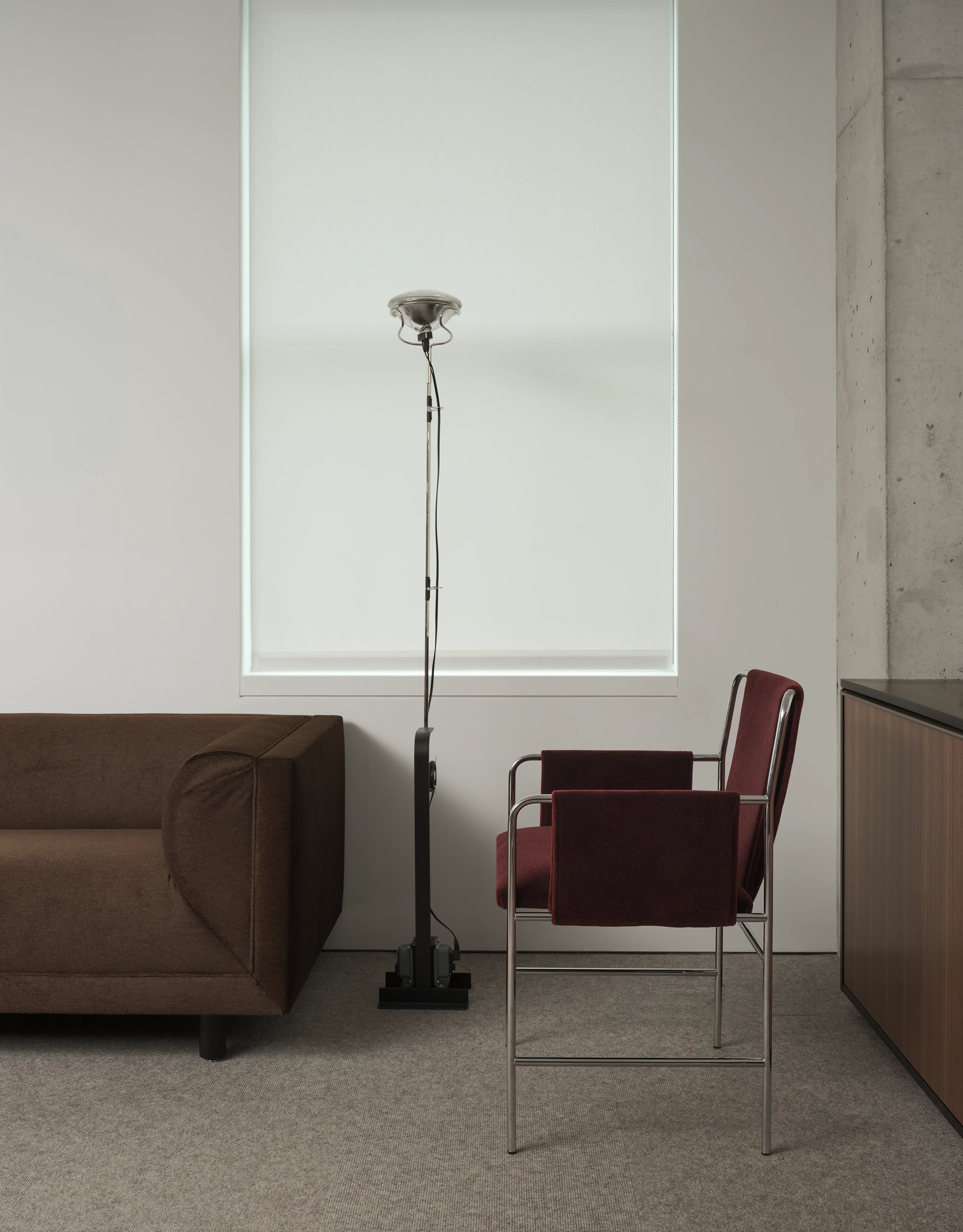 An Envelope Chair upholstered with Knoll Velvet in Wine with a chrome frame beside a Rolled Arm Sofa upholstered with Alpaca Mohair in Umber in a private office setting.