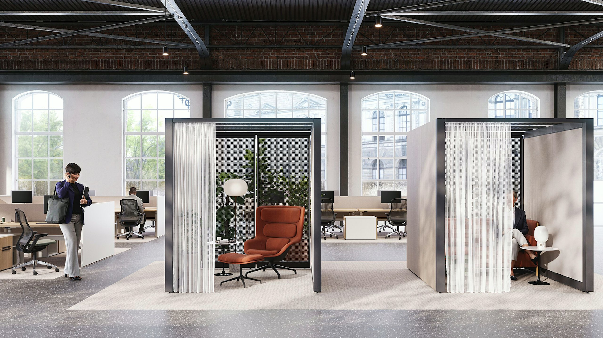 An open, brightly lit space with brick walls and floor-to-ceiling windows featuring Knoll Rockwell Unscripted Creative Walls, Saarinen Side Tables, burnt-orange lounge chairs, and lighting from Design Within Reach.