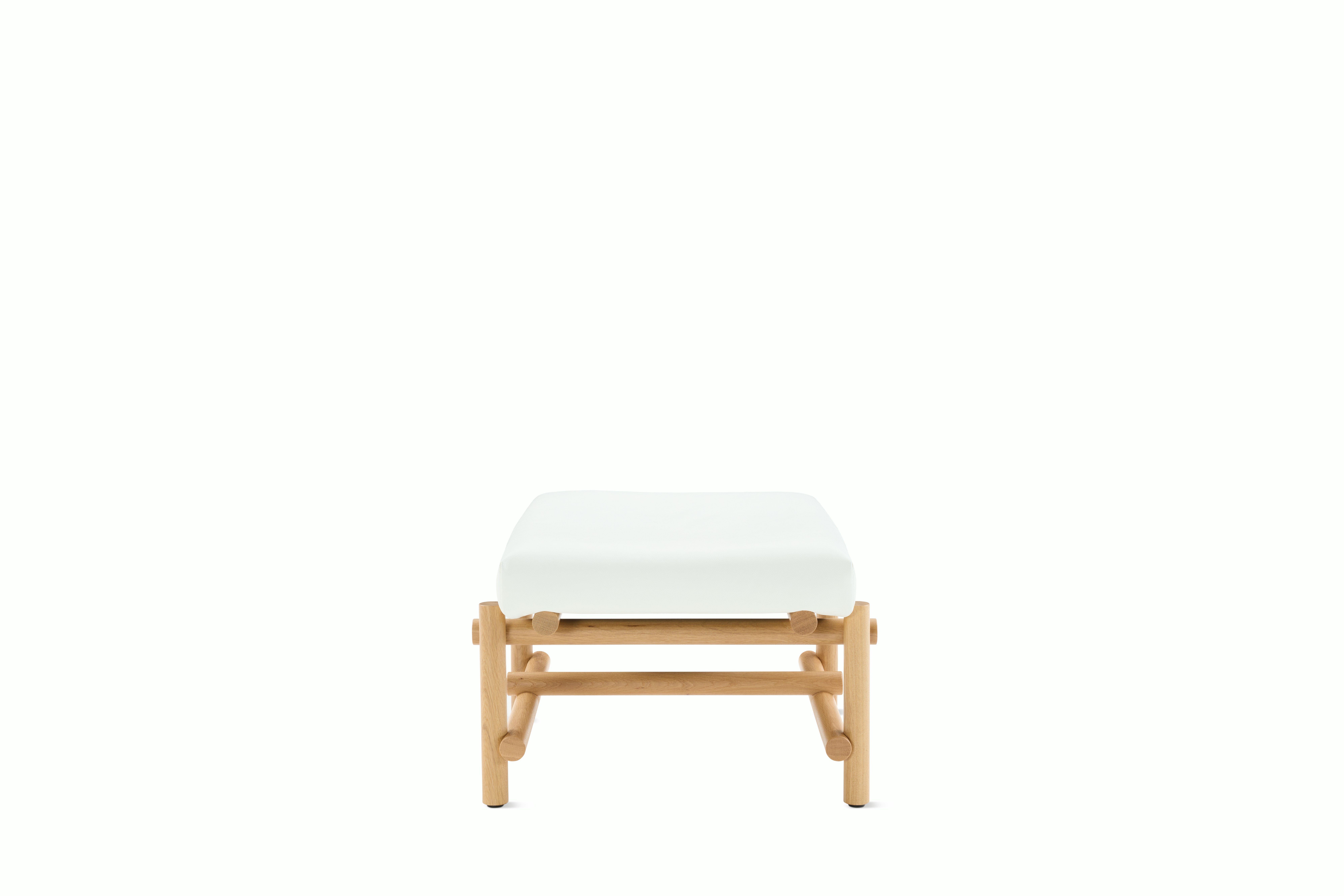 A Muecke Ottoman in White White Oak viewed from the side.