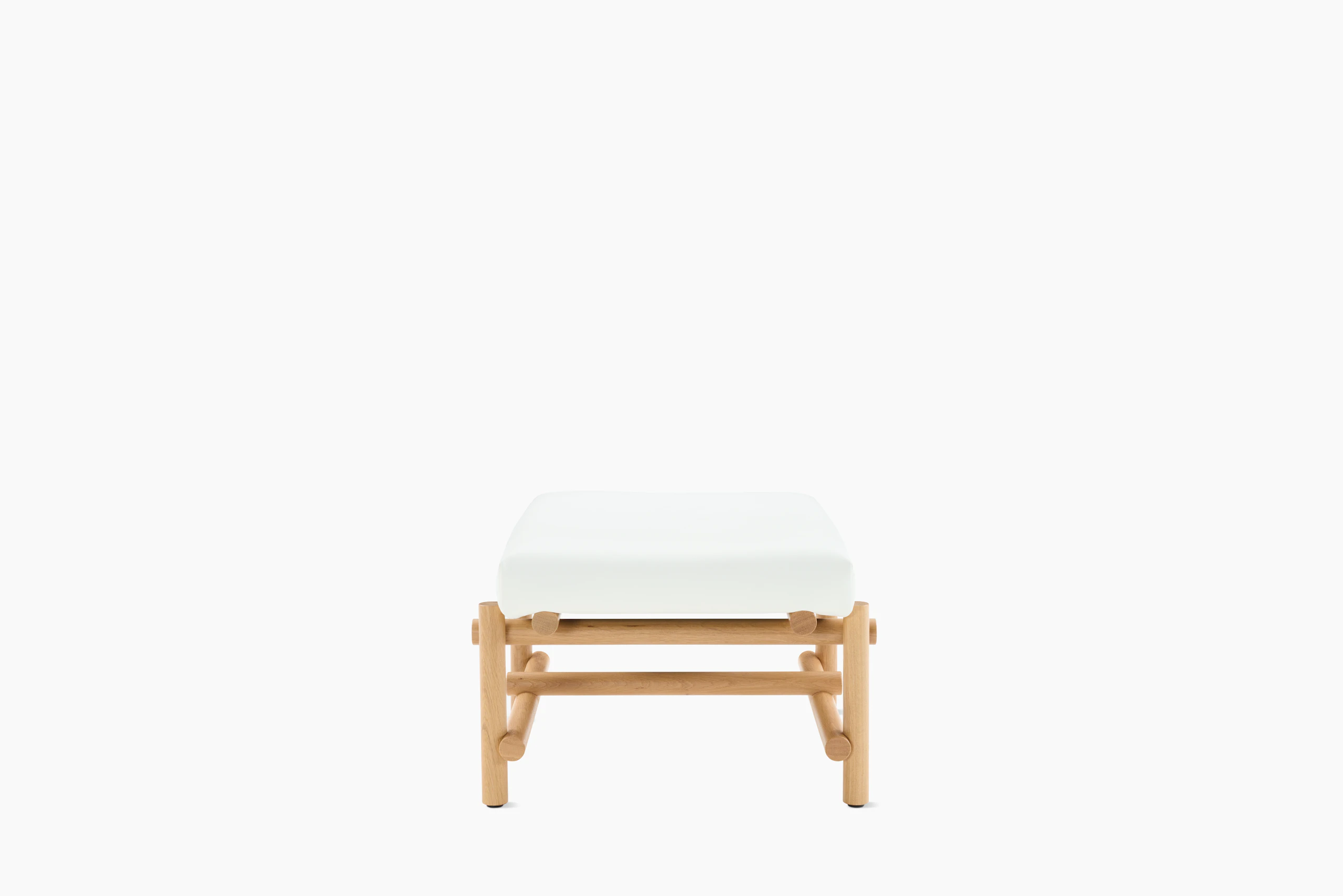 A Muecke Ottoman in White White Oak viewed from the side.