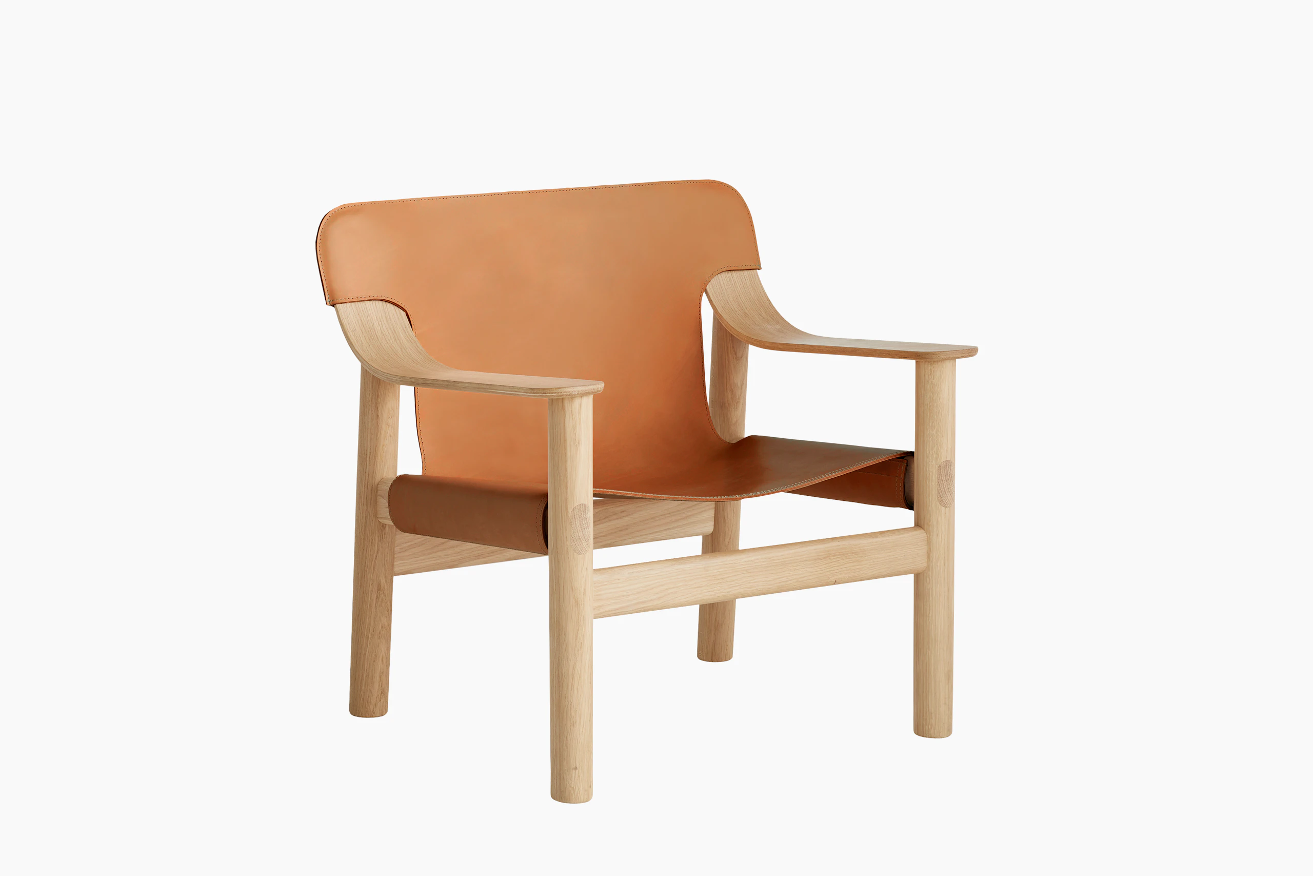 A front angle view of the Bernard Lounge Chair with oak frame and cognac leather seat and back.