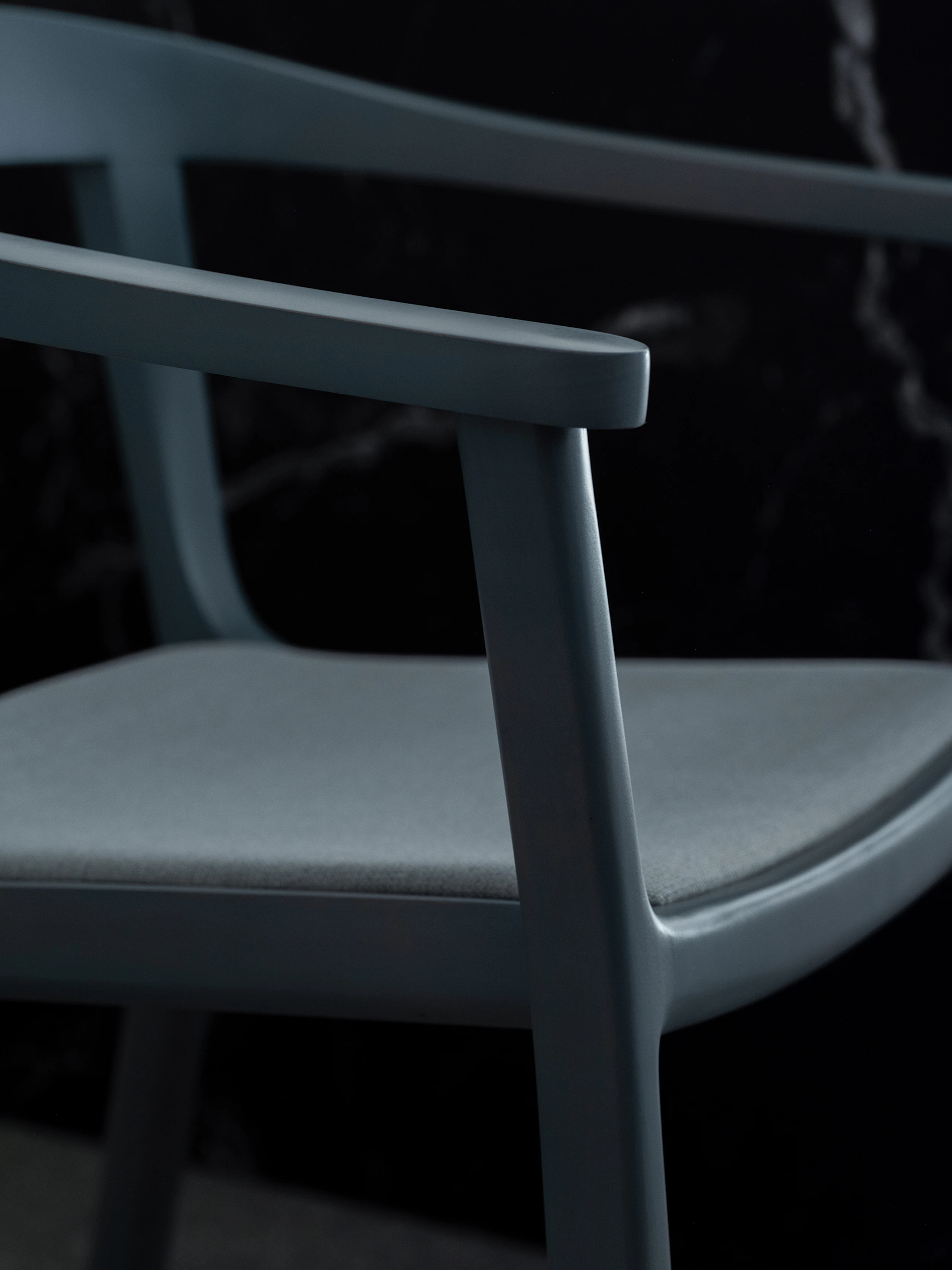 Detail view of a Lijn Armchair frame and seat in Nordic Blue with the seat upholstered with Luce in Brine, viewed at an angle.