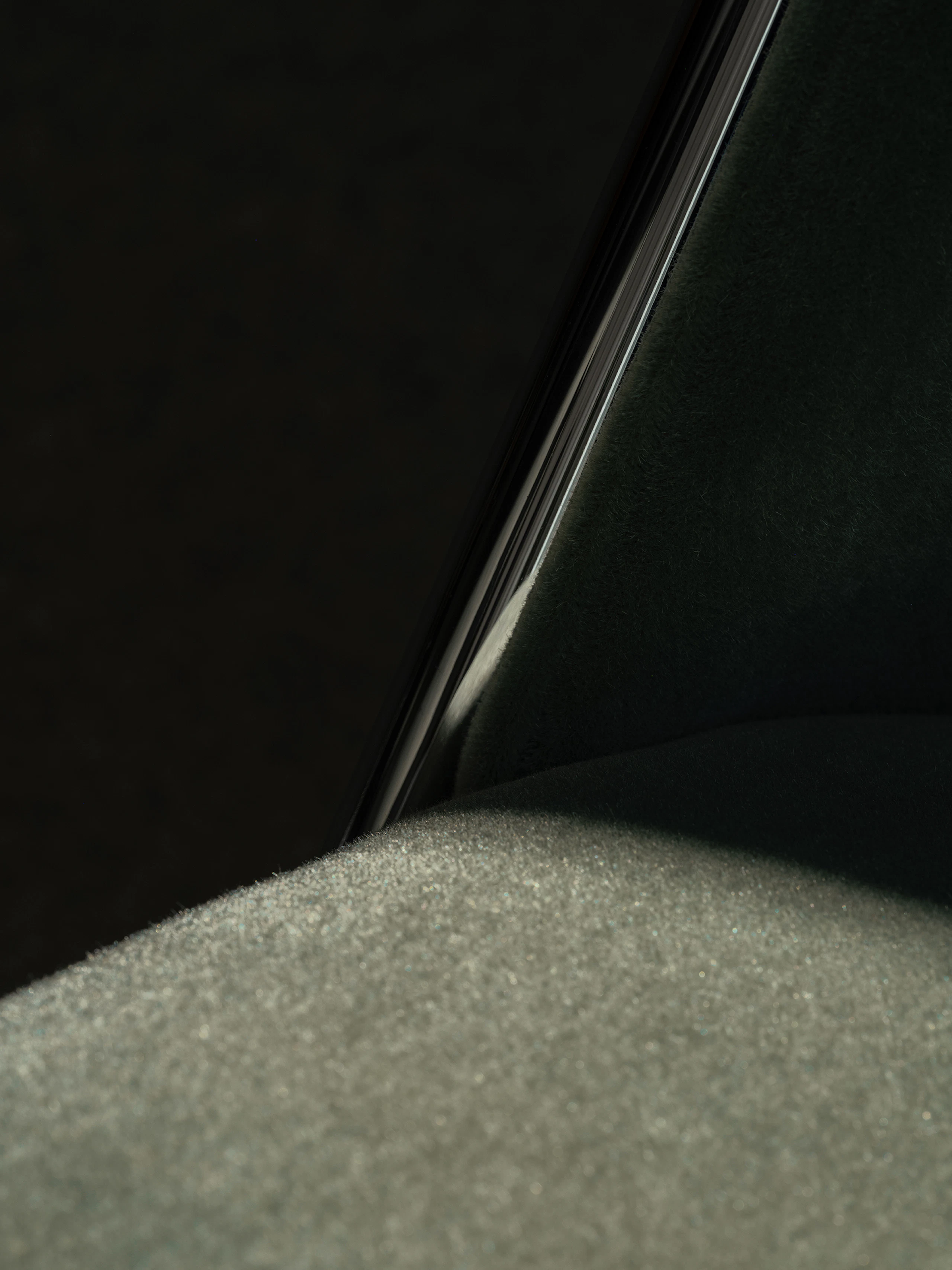 Detail view of a Scissor Chair seat and backrest upholstered with Mohair Supreme in Grassland with a chrome frame, viewed at an angle.