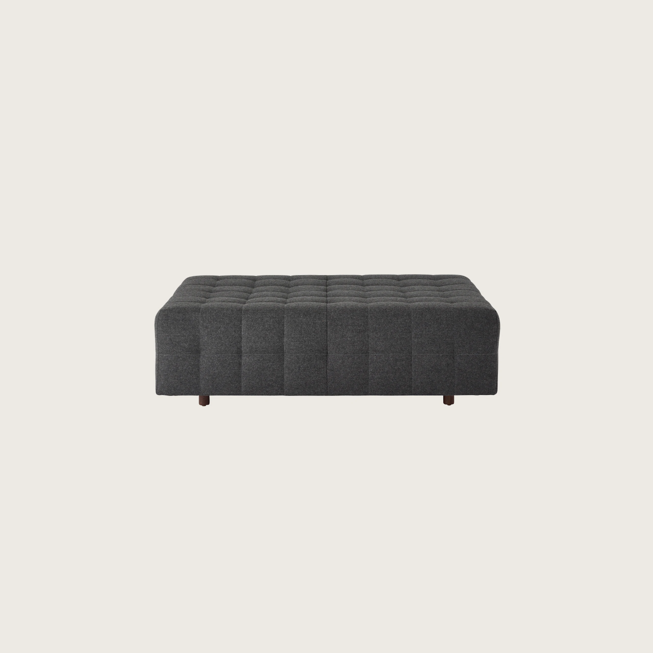 A Rapport ottoman upholstered in a dark grey fabric.