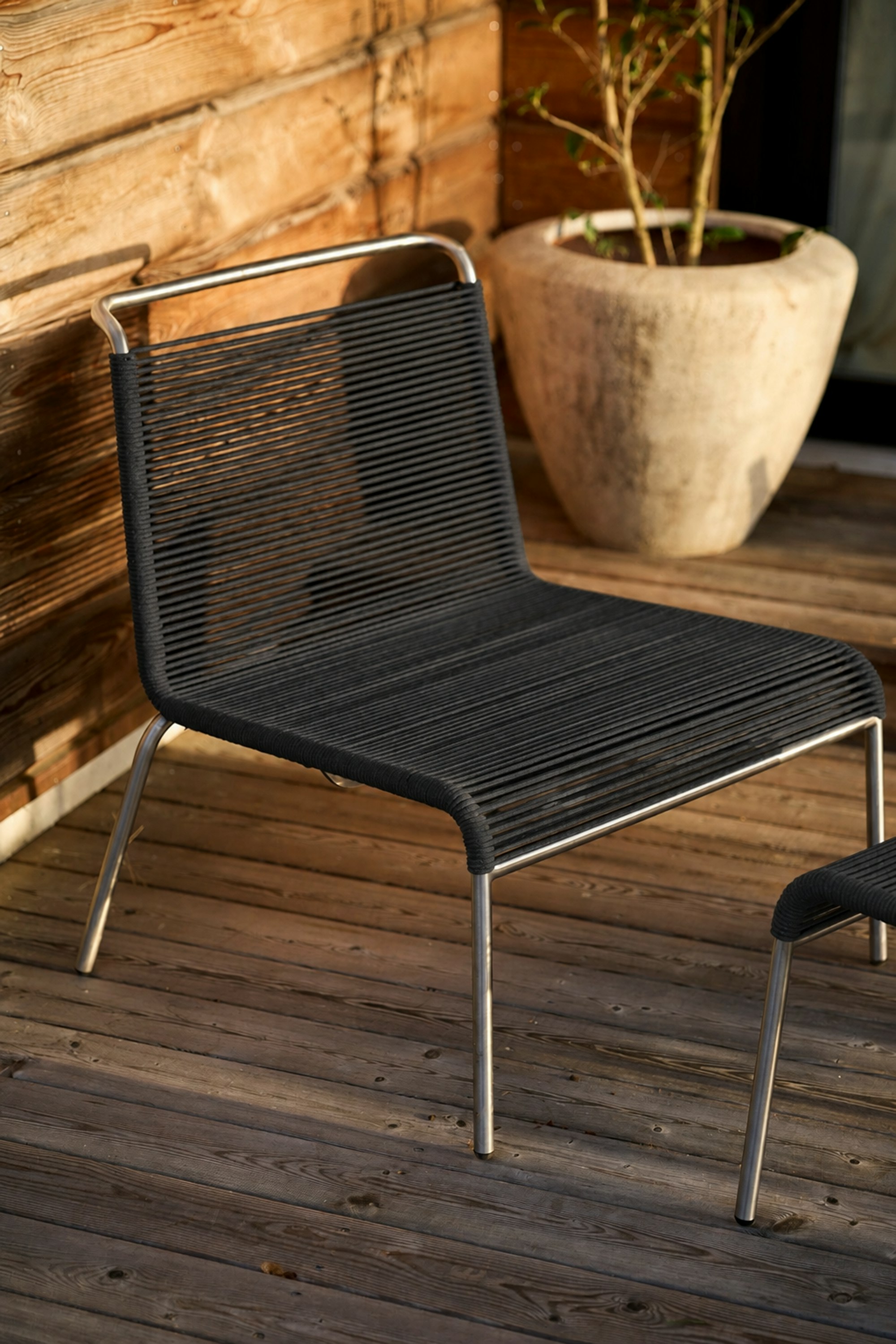 An environmental shot of Teglgaard Outdoor Lounge Chair in Black.