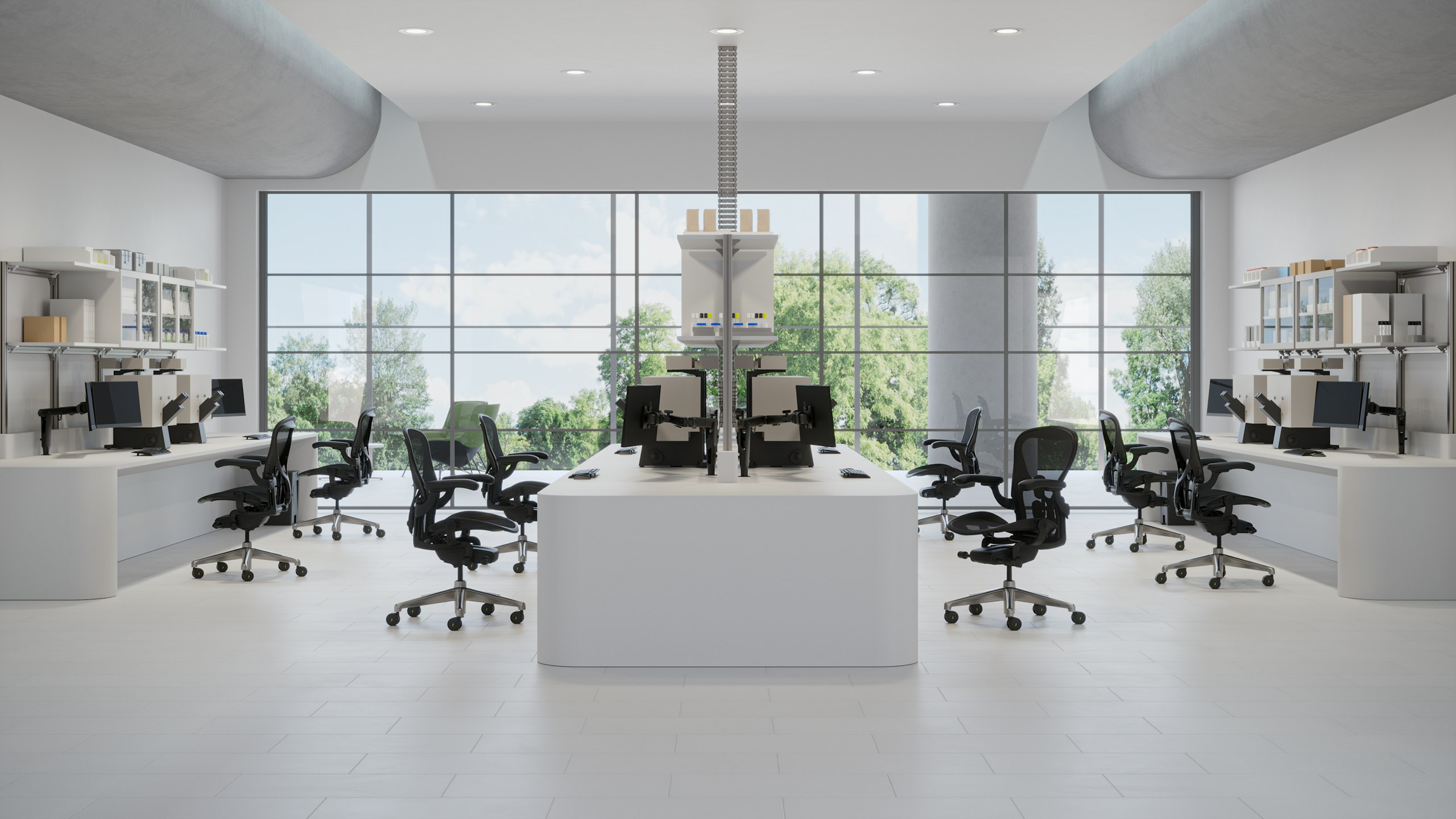 Eight Aeron ESD chairs in a light lab space with two desks on each side and a desk in the center. Each station has monitors and books and manuals.