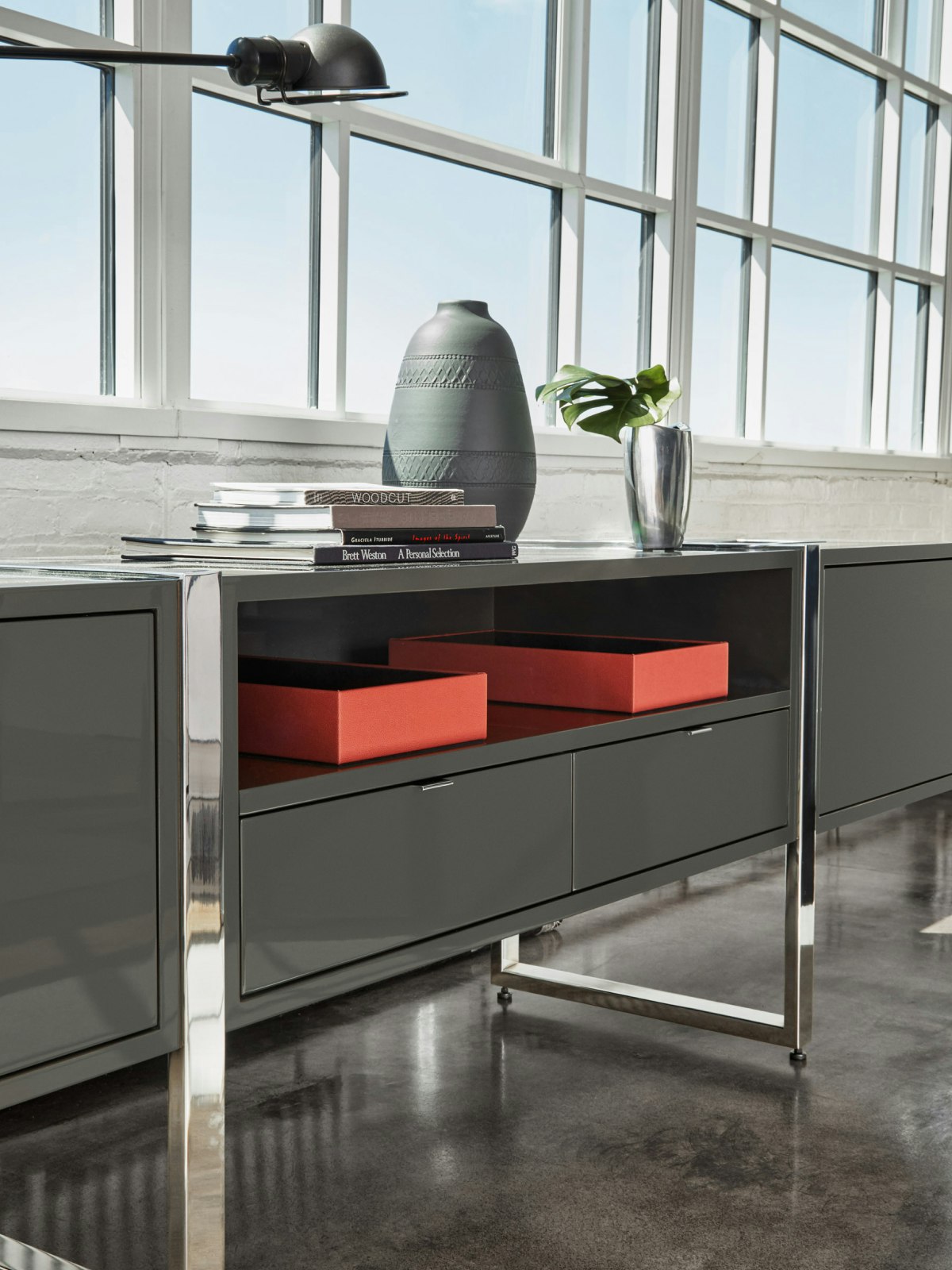 Highline Credenza with Umbra Grey Case and Polished Chrome Base in an office setting; angled view.