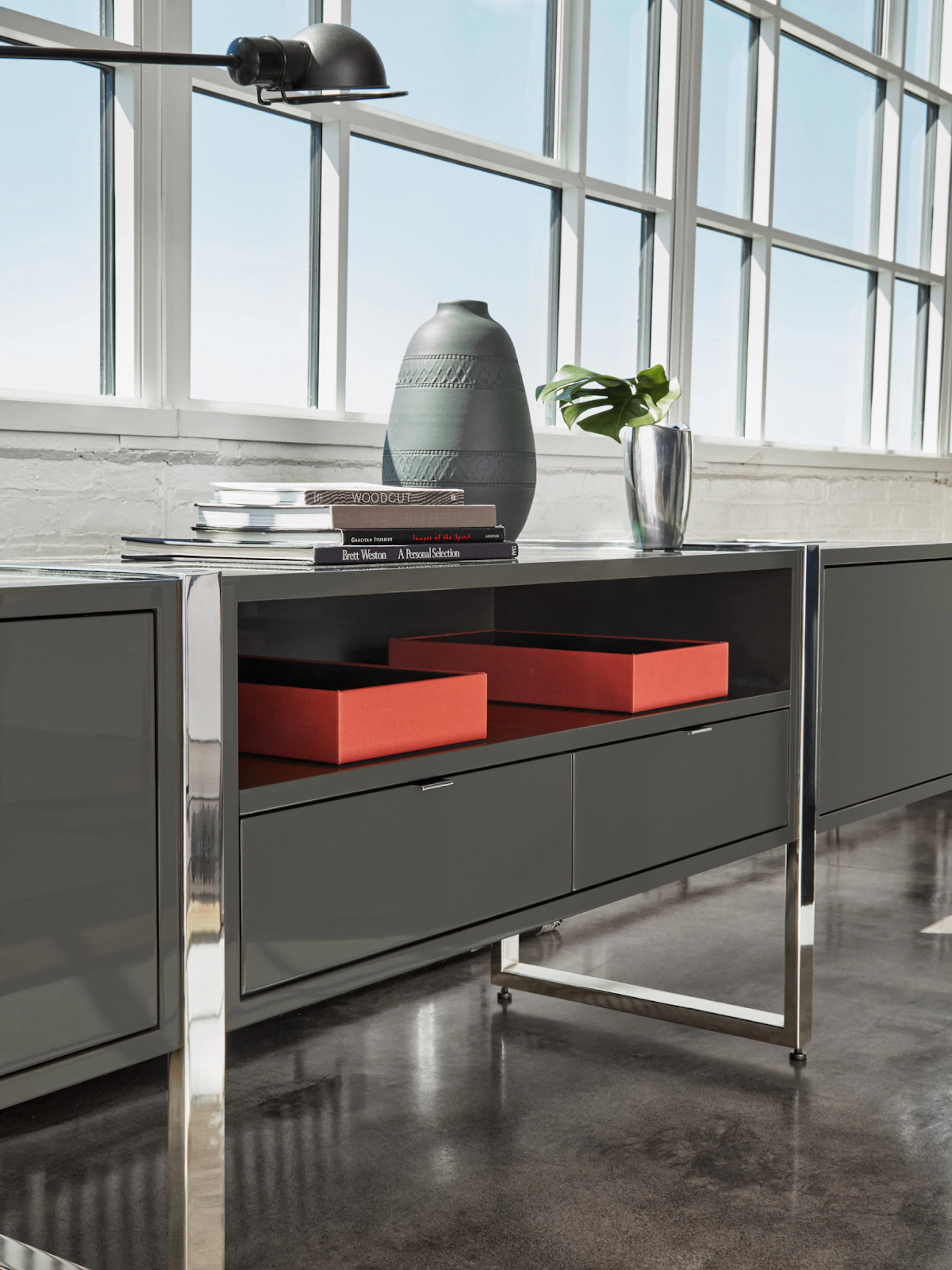 Highline Credenza with Umbra Grey Case and Polished Chrome Base in an office setting; angled view.