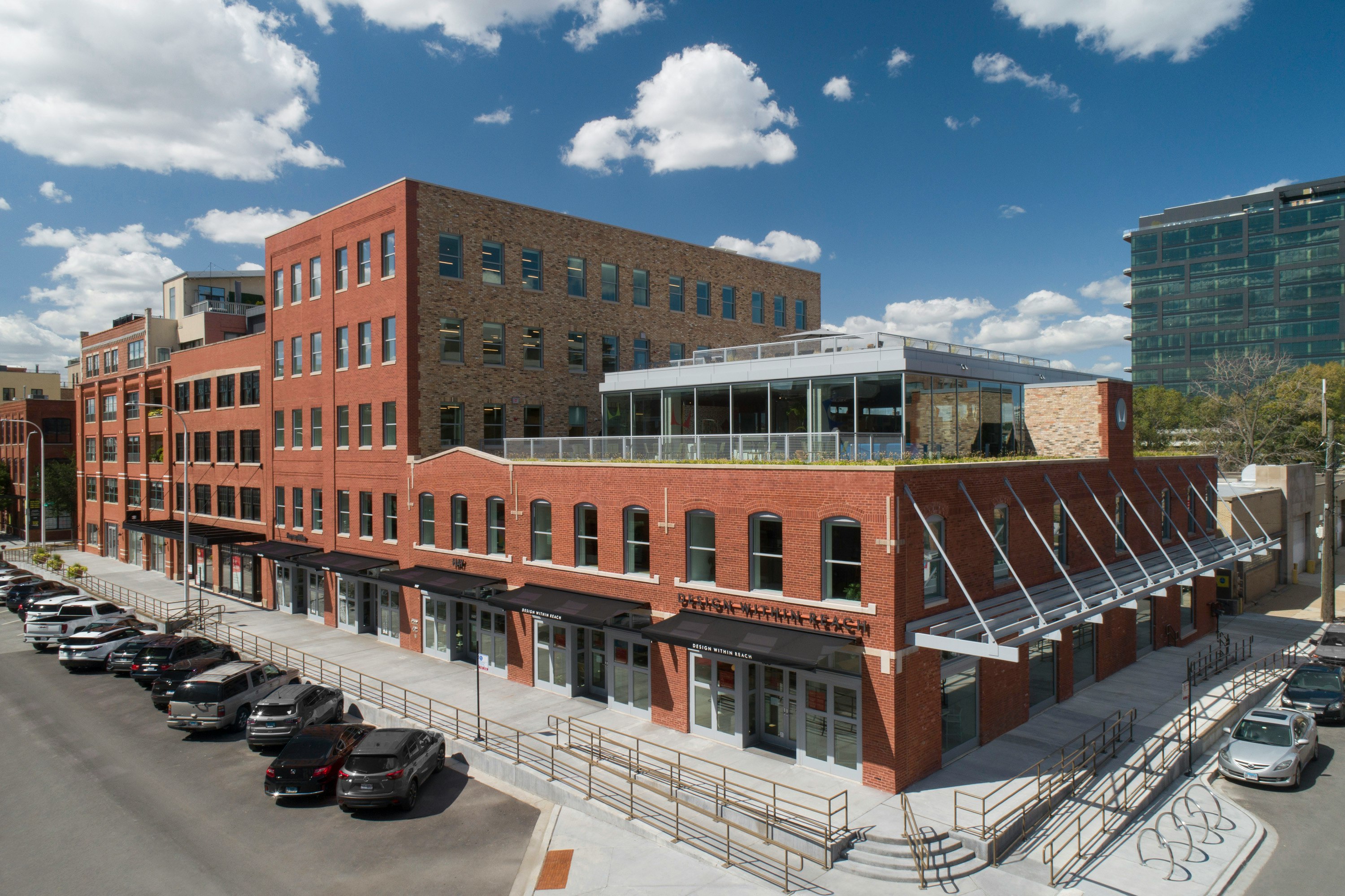 An angle view of the red-brick MillerKnoll Showroom at 1100 W. Fulton Market in Chicago on a sunny afternoon.
