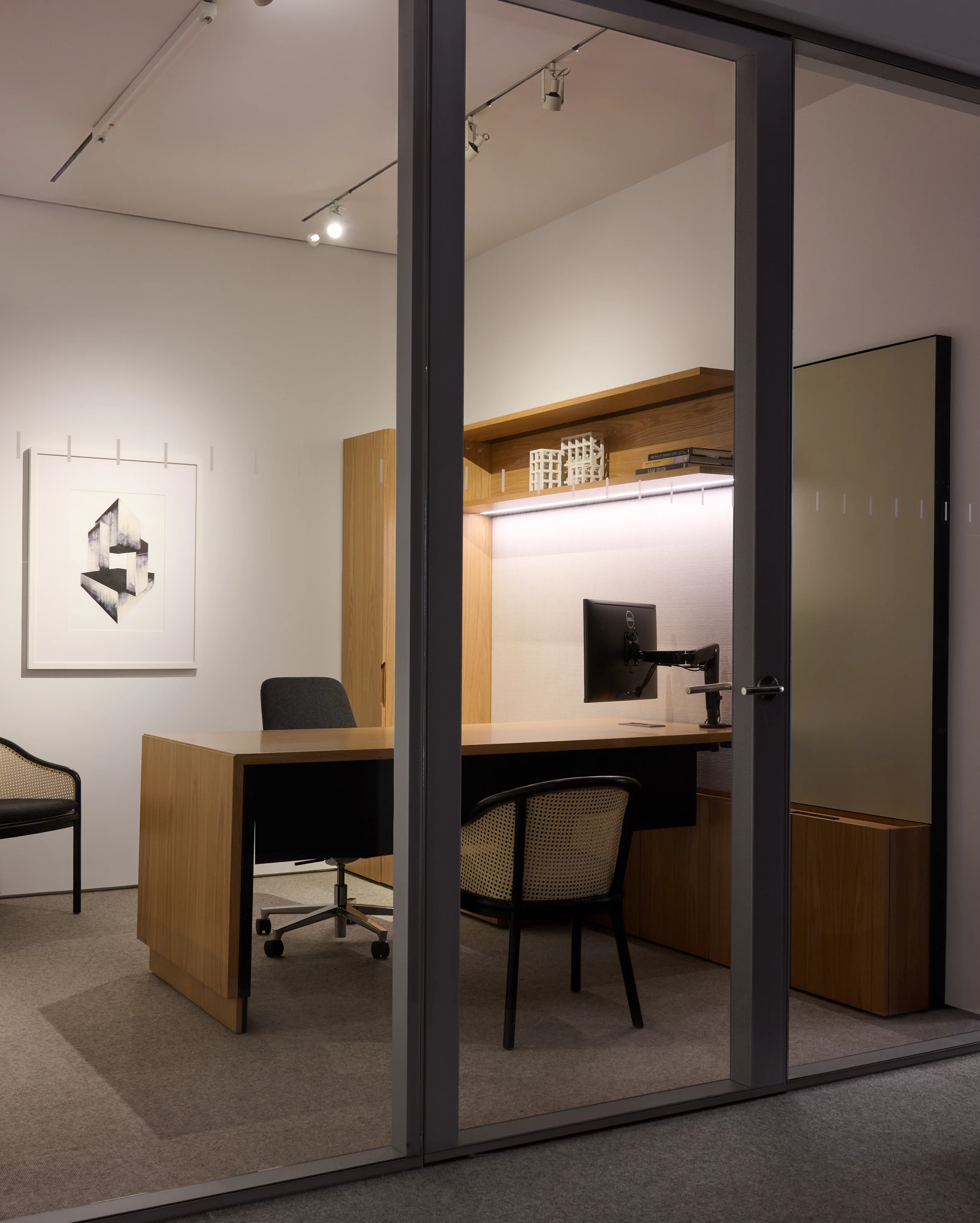 Geiger One Private Office in Natural Flat Cut Oak with a height adjustable Cascade leg, two Landmark Chairs for guests, and a Saiba Chair, viewed at an angle.