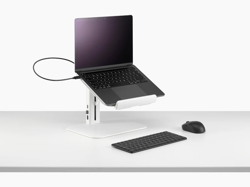Lana laptop stand with laptop keyboard and mouse in white viewed from a sided angle.
