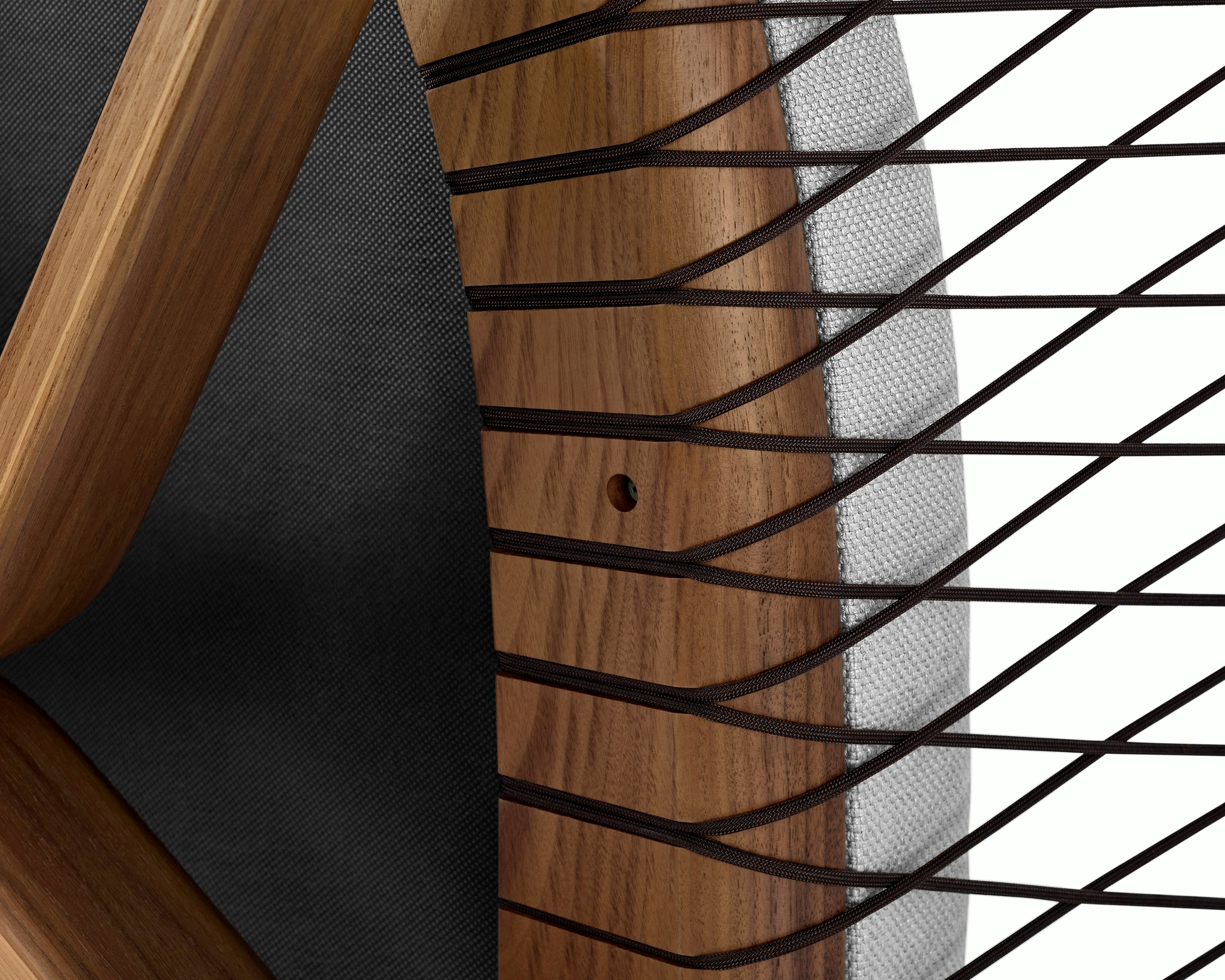 Partial view of a Crosshatch Chair, focusing on the parachute cords that support the wood frame.