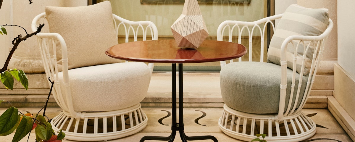Two Grace Outdoor Chairs and a side table in an atrium setting