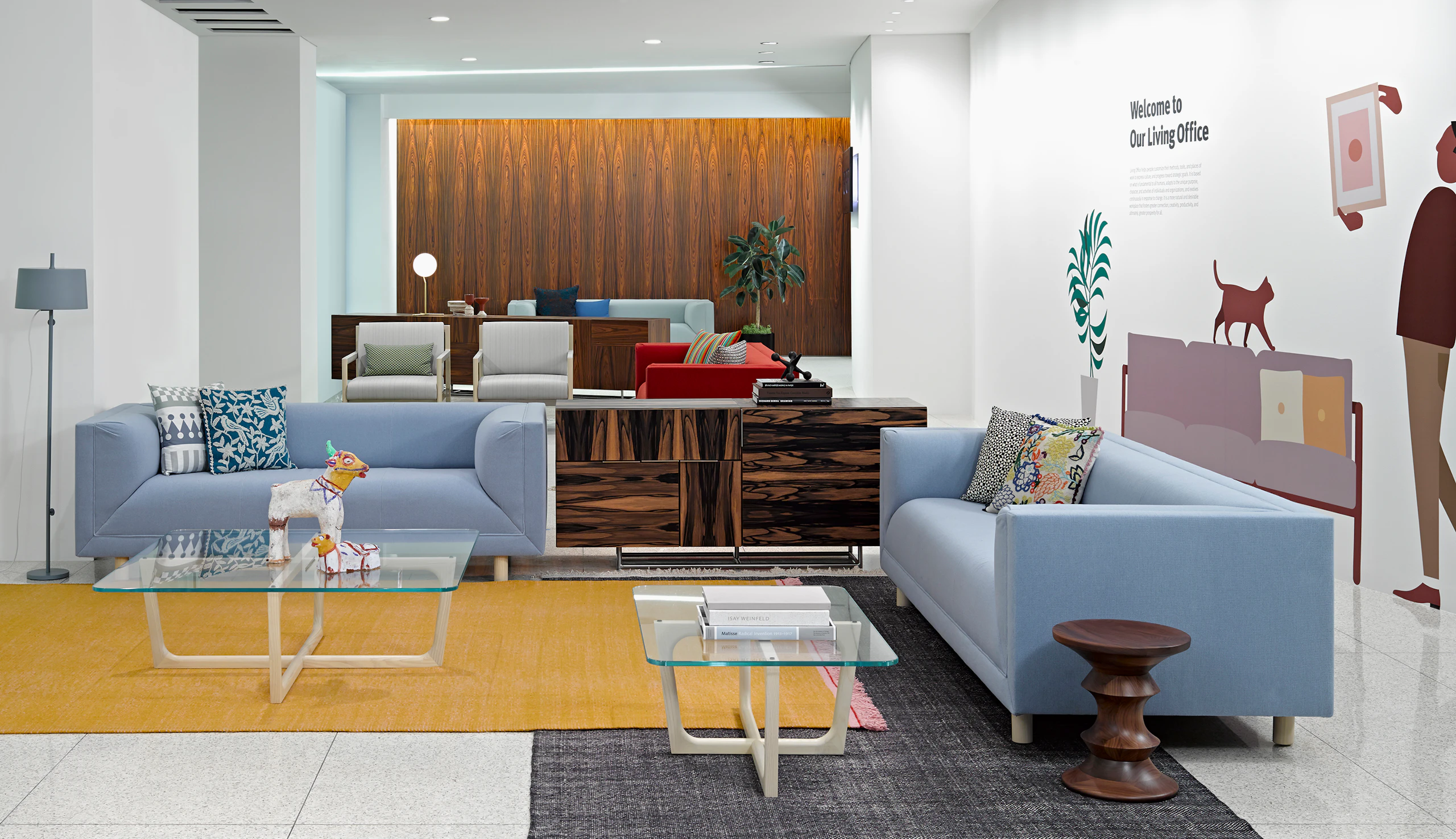 A lounge featuring two Brabo club chairs with ivory-colored upholstery and four Rolled Arm sofas in various colors.