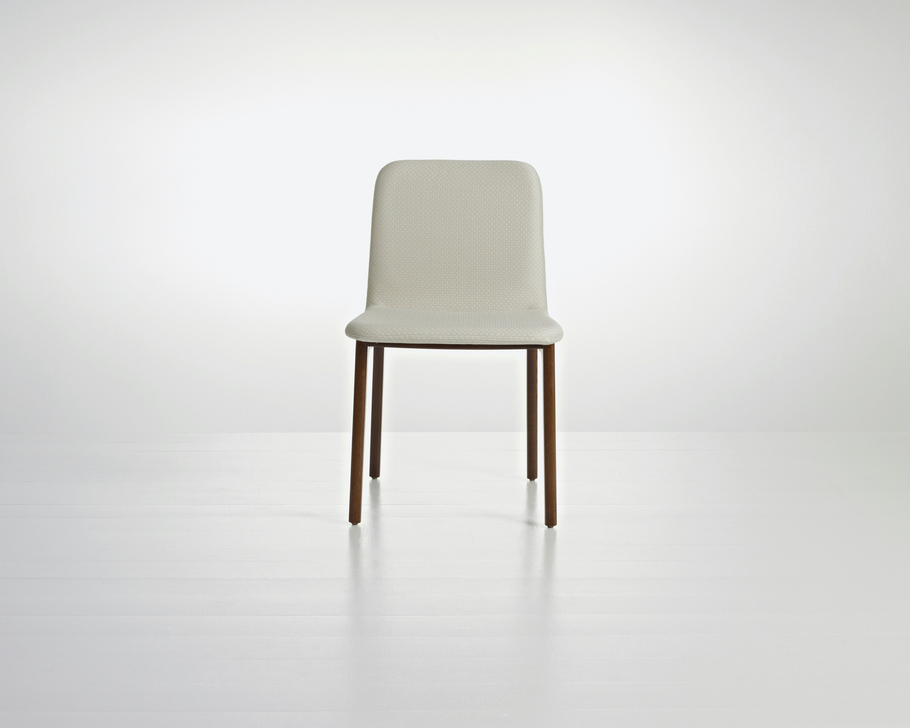 A Deft side chair with ivory-colored fabric, a wood frame in a medium finish, and no arms, viewed from the front.