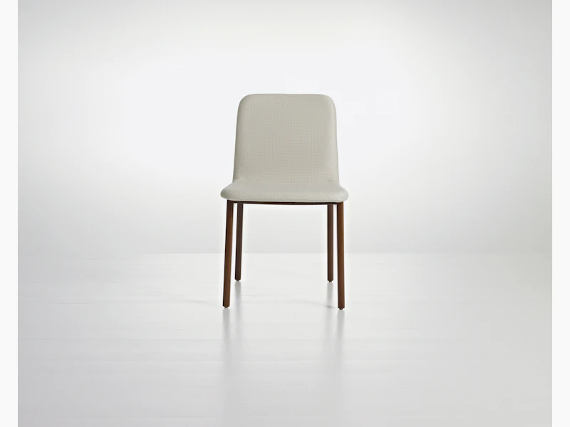 A Deft side chair with ivory-colored fabric, a wood frame in a medium finish, and no arms, viewed from the front.