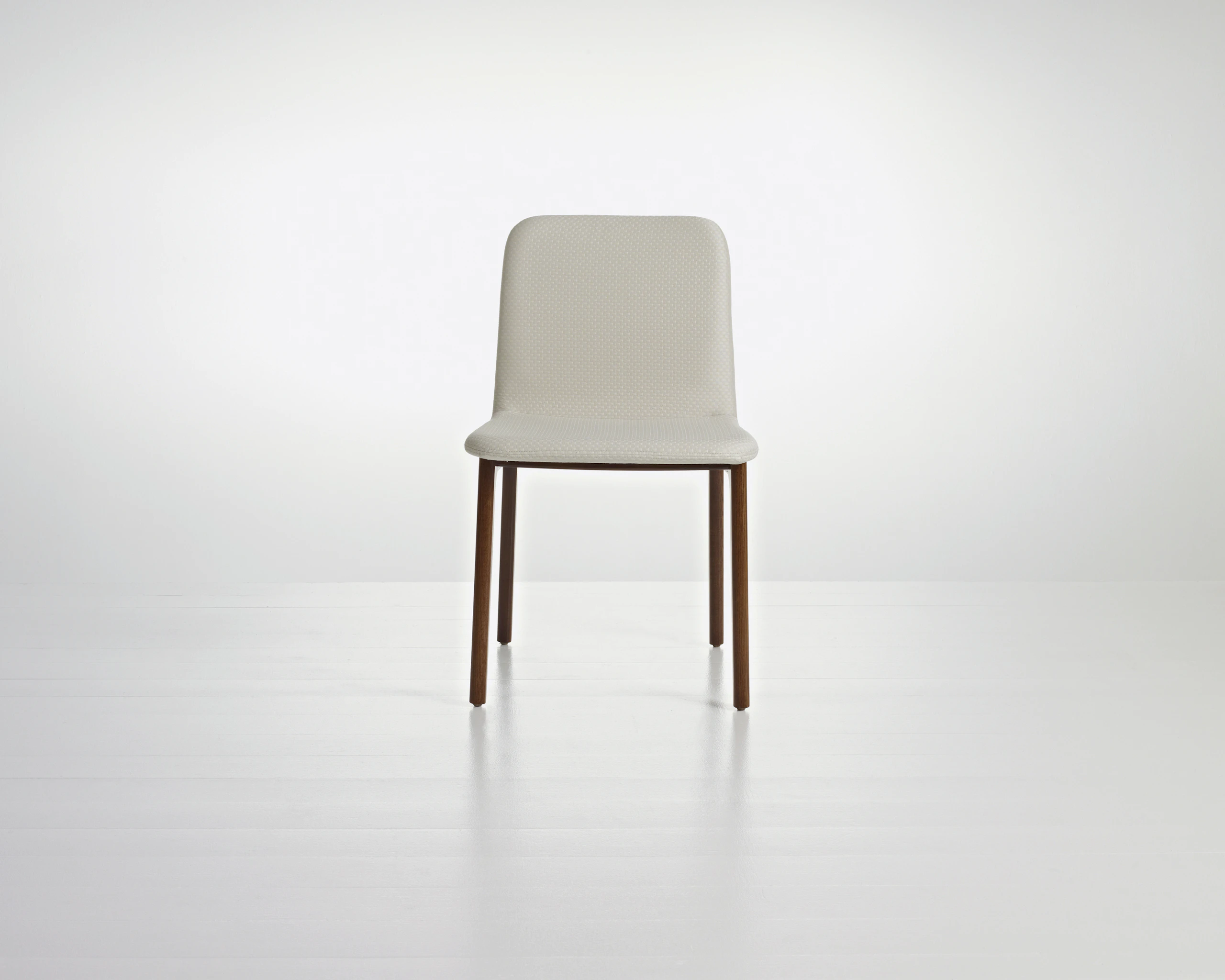 A Deft side chair with ivory-colored fabric, a wood frame in a medium finish, and no arms, viewed from the front.