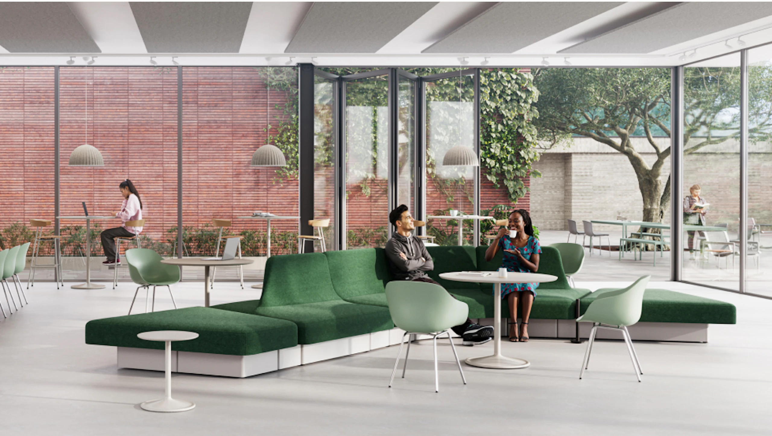 Modern lounge area with green modular sofa, light wood tables, and various seating options. Large windows overlook a green space with trees.