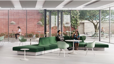 Área de estar moderna con sofá modular verde, mesas de madera clara y varias opciones de asientos. Grandes ventanales dan a un espacio verde con árboles.