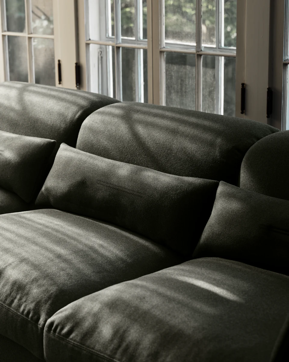 Living room scene with dark green sofa and glass coffee table