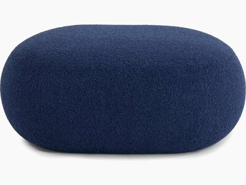 A Biboni Ottoman in Solid Sublime, Navy viewed from the side.