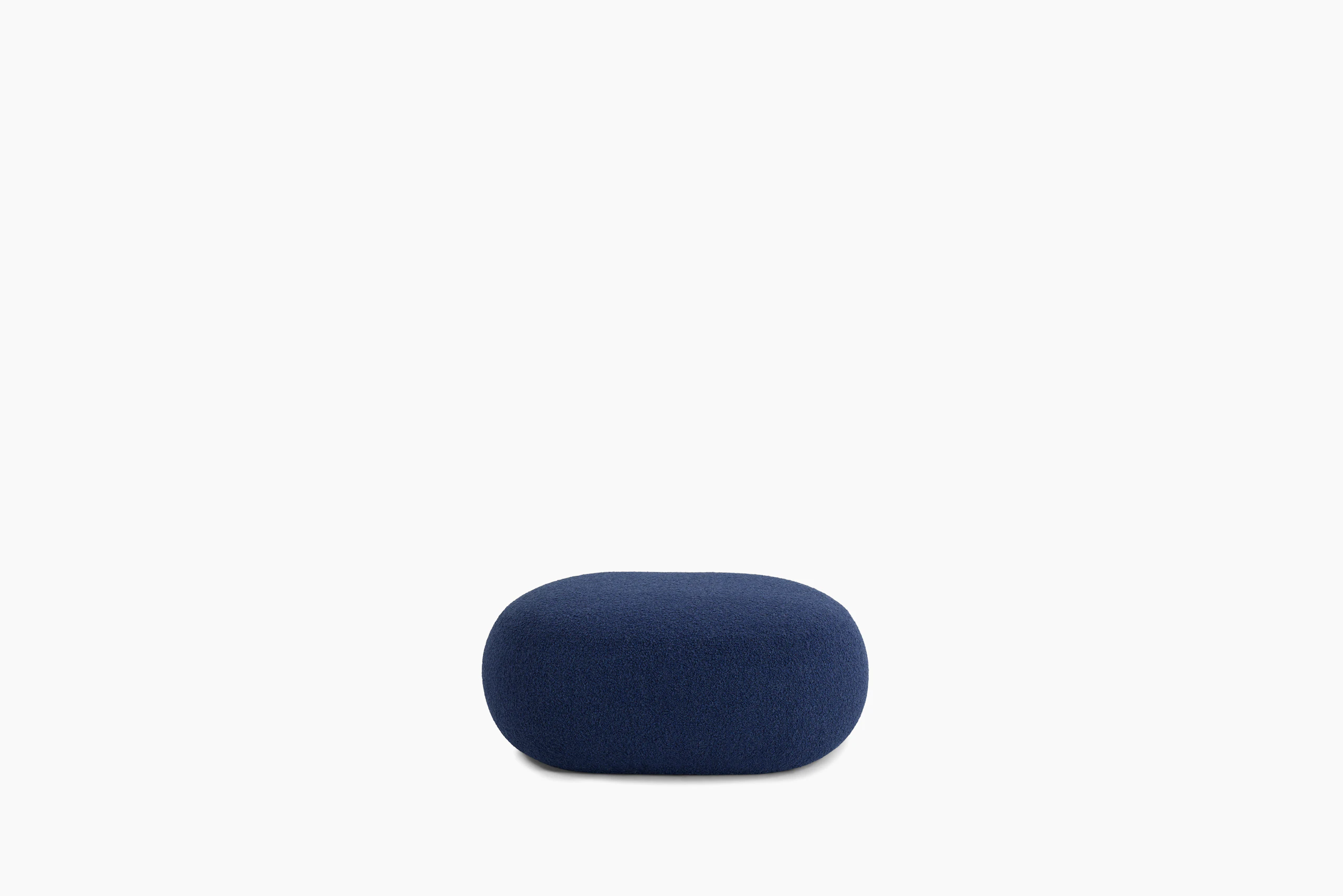 A Biboni Ottoman in Solid Sublime, Navy viewed from the side.