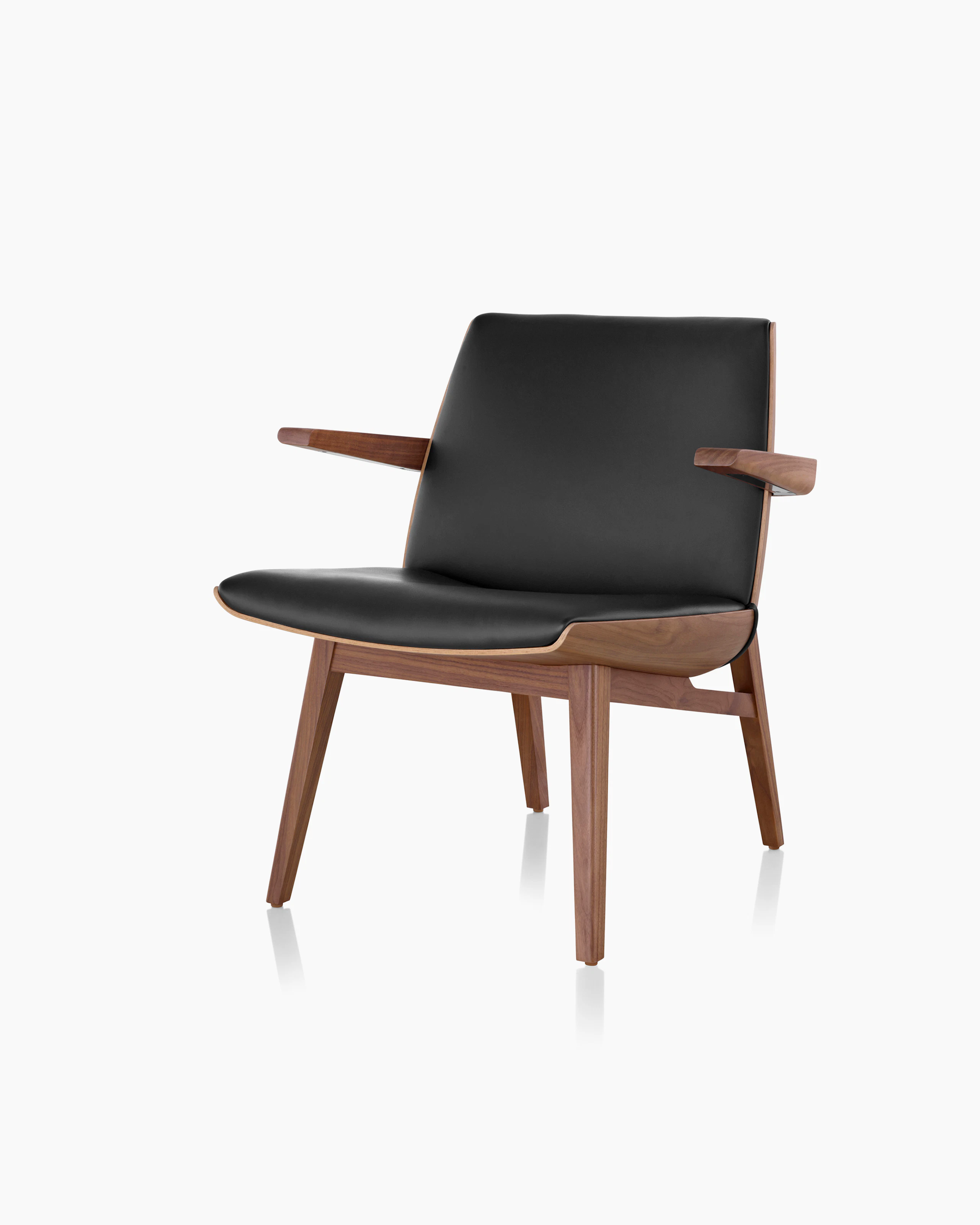 Angled view of a low-back Clamshell Lounge Chair with black leather upholstery and four wood legs.