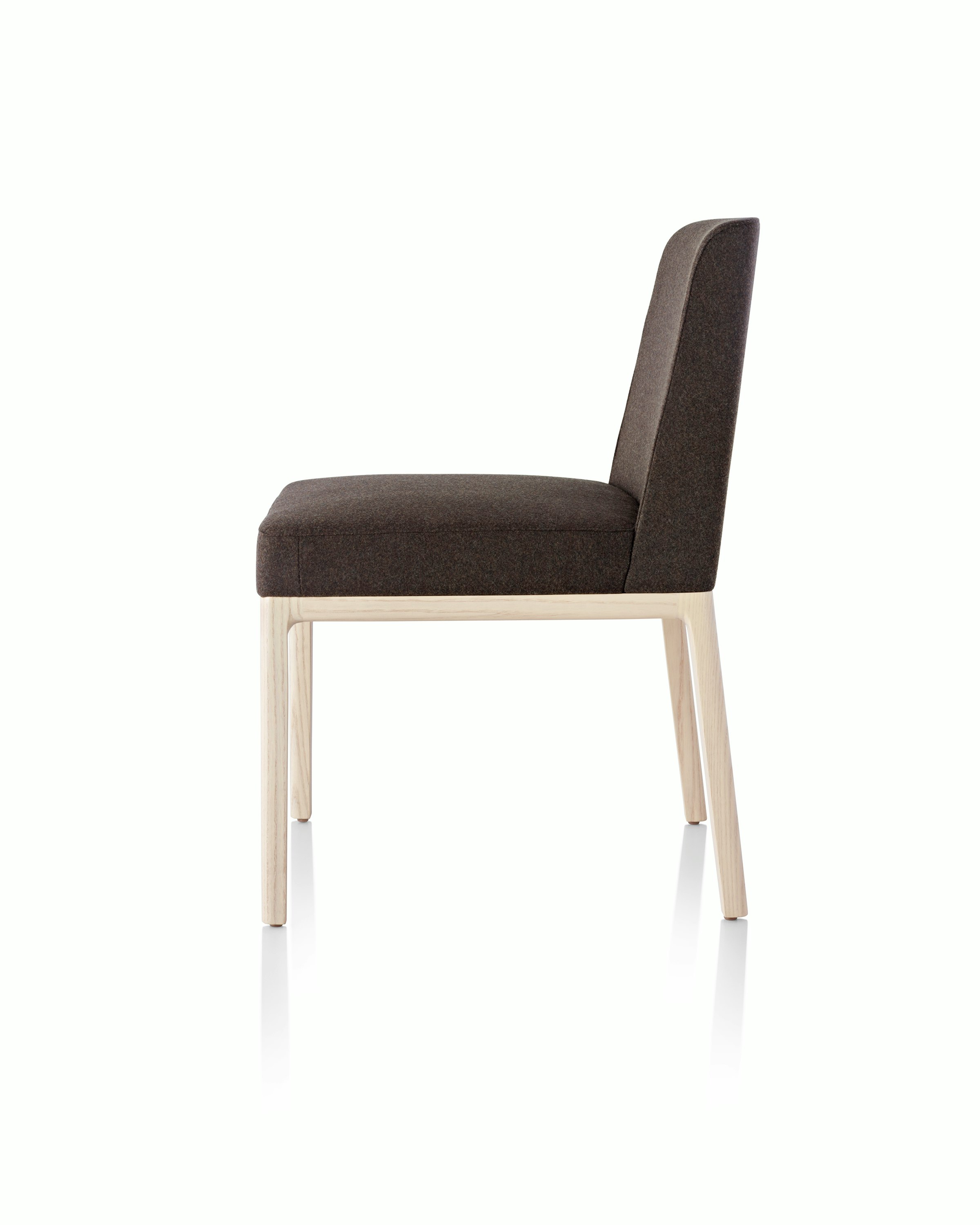 Side view of an armless Nessel side chair with black fabric upholstery and a wood frame with a light finish.