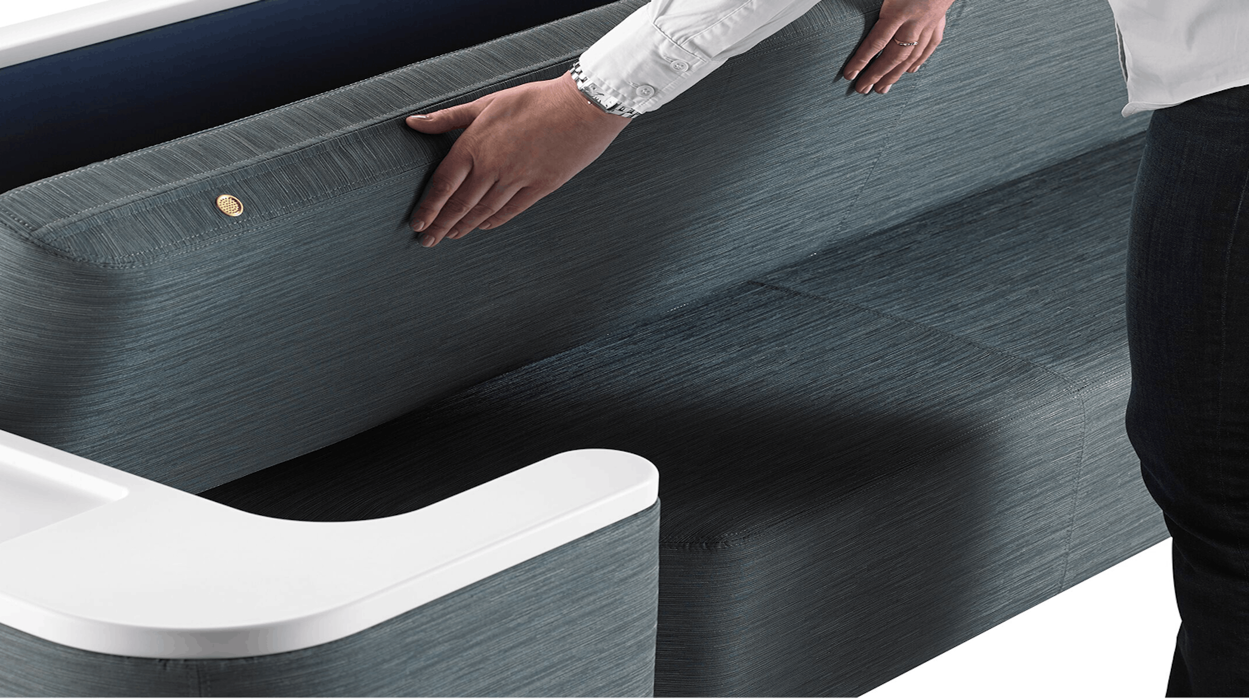 A person positioning the back of a Nemschoff Palisade Flop Sofa into a sleep surface.