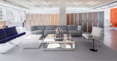 The Knoll showroom at MillerKnoll Design Days furnished with two purple velvet Knoll Barcelona Chairs, a tuxedo Biboni Sofa, and two large glass coffee tables