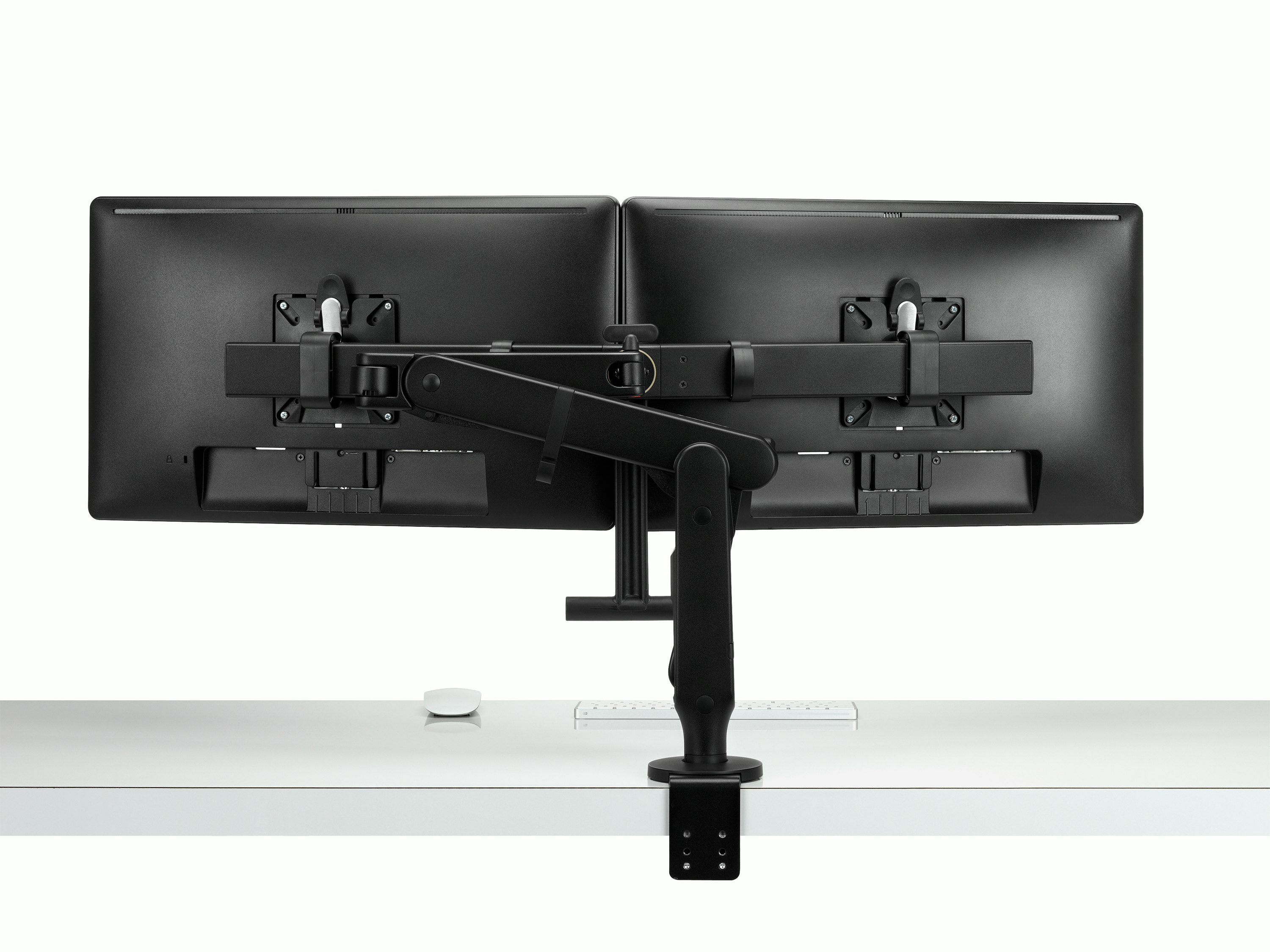 Back view of two monitors attached to a black Ollin Monitor Arm in dual configuration, and with the optional dual bar handle added to support ease of adjustment of screen position.