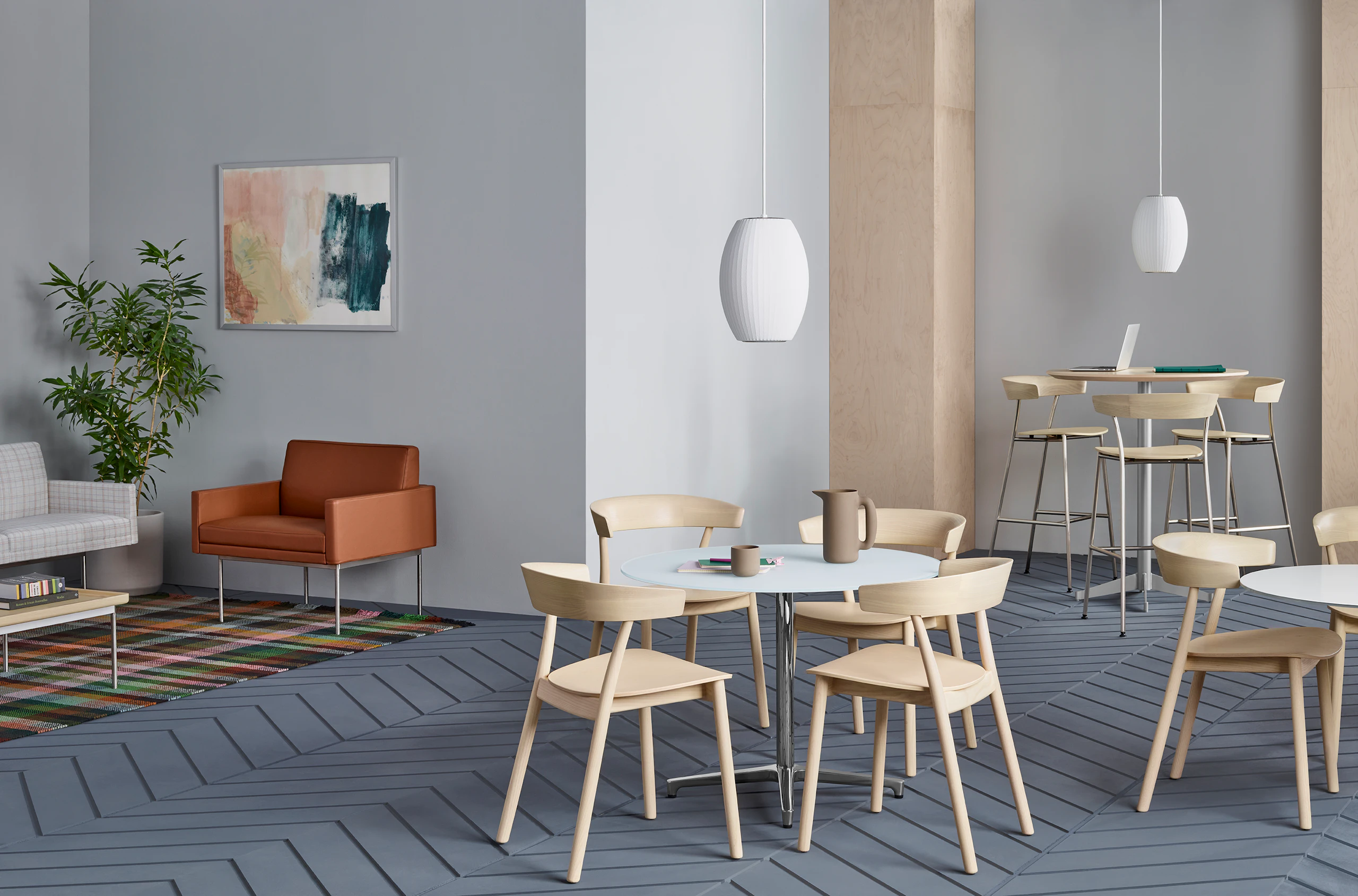 A lounge space featuring various seating types, including all-wood Leeway side chairs, Leeway Stools, and Tuxedo Component Lounge Seating.