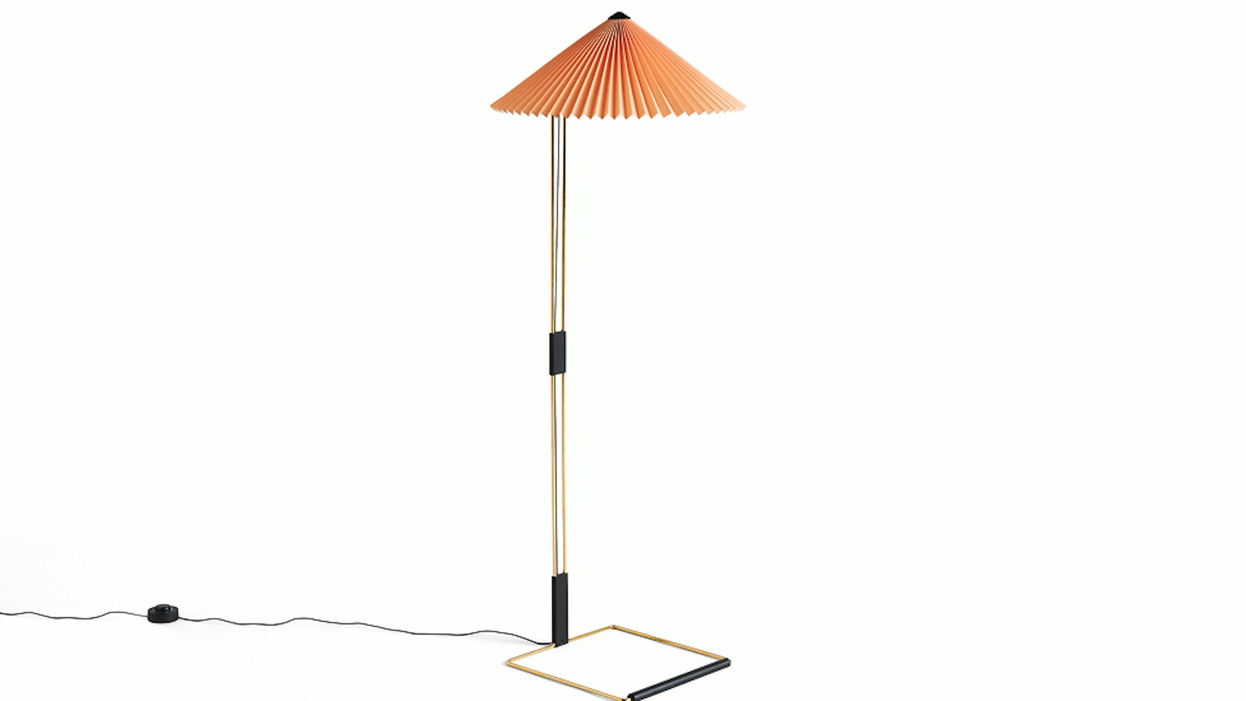 A Matin Floor Lamp by HAY with a gold and black frame and orange lampshade
