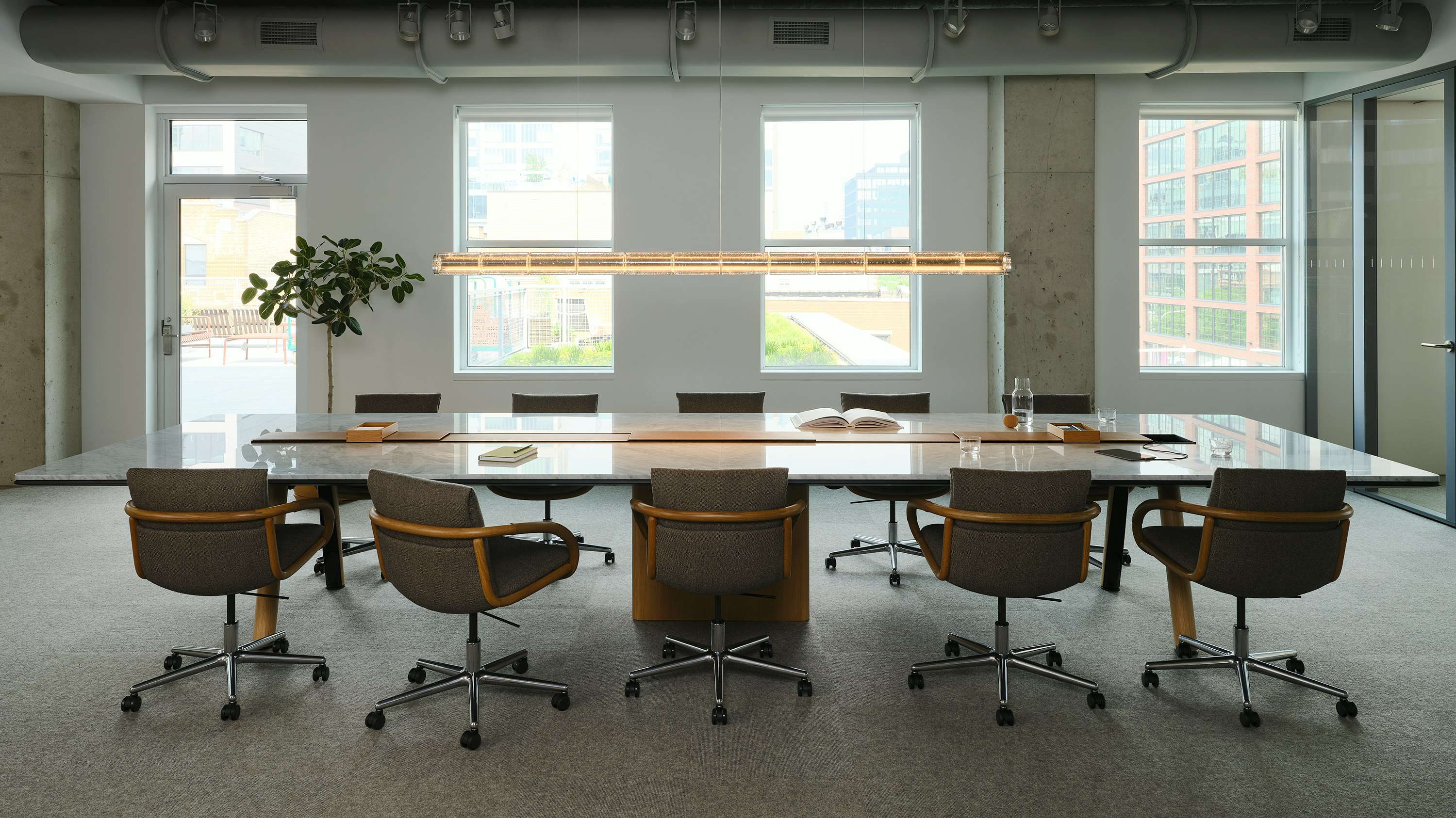Ascent Conference Table with Full Loop Chairs by Geiger, both designed by EOOS, in Carrara Marble and Natural Rift Cut Oak shown in the Geiger DatesWeiser Chicago Showroom