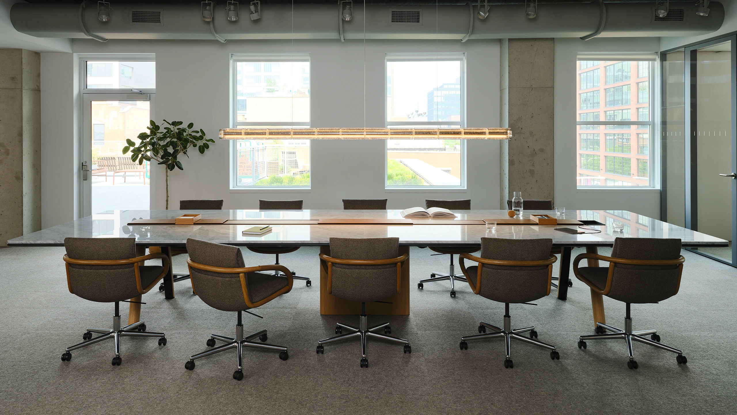 Ascent Conference Table with Full Loop Chairs by Geiger, both designed by EOOS, in Carrara Marble and Natural Rift Cut Oak shown in the Geiger DatesWeiser Chicago Showroom