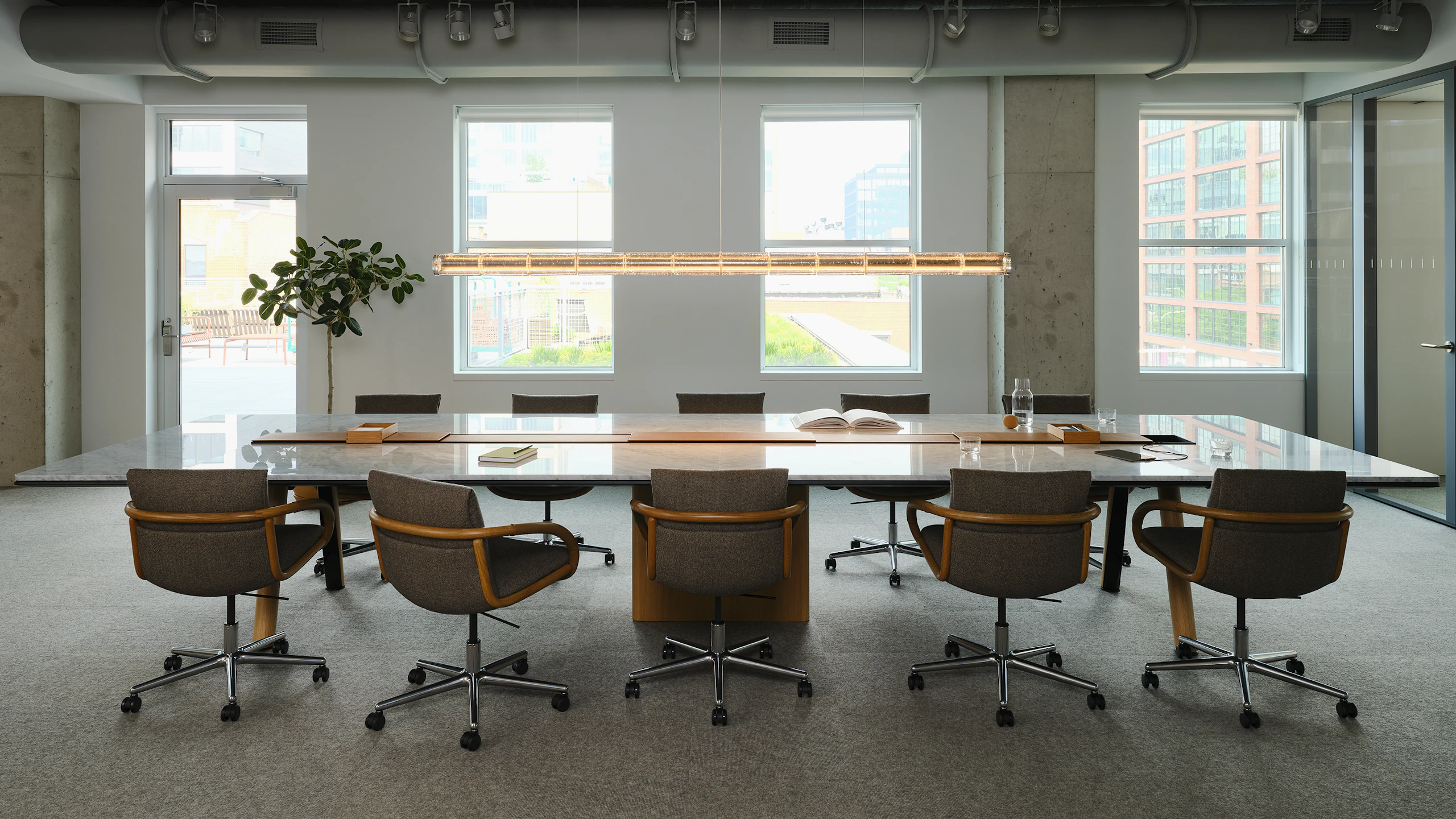 Ascent Conference Table with Full Loop Chairs by Geiger, both designed by EOOS, in Carrara Marble and Natural Rift Cut Oak shown in the Geiger DatesWeiser Chicago Showroom
