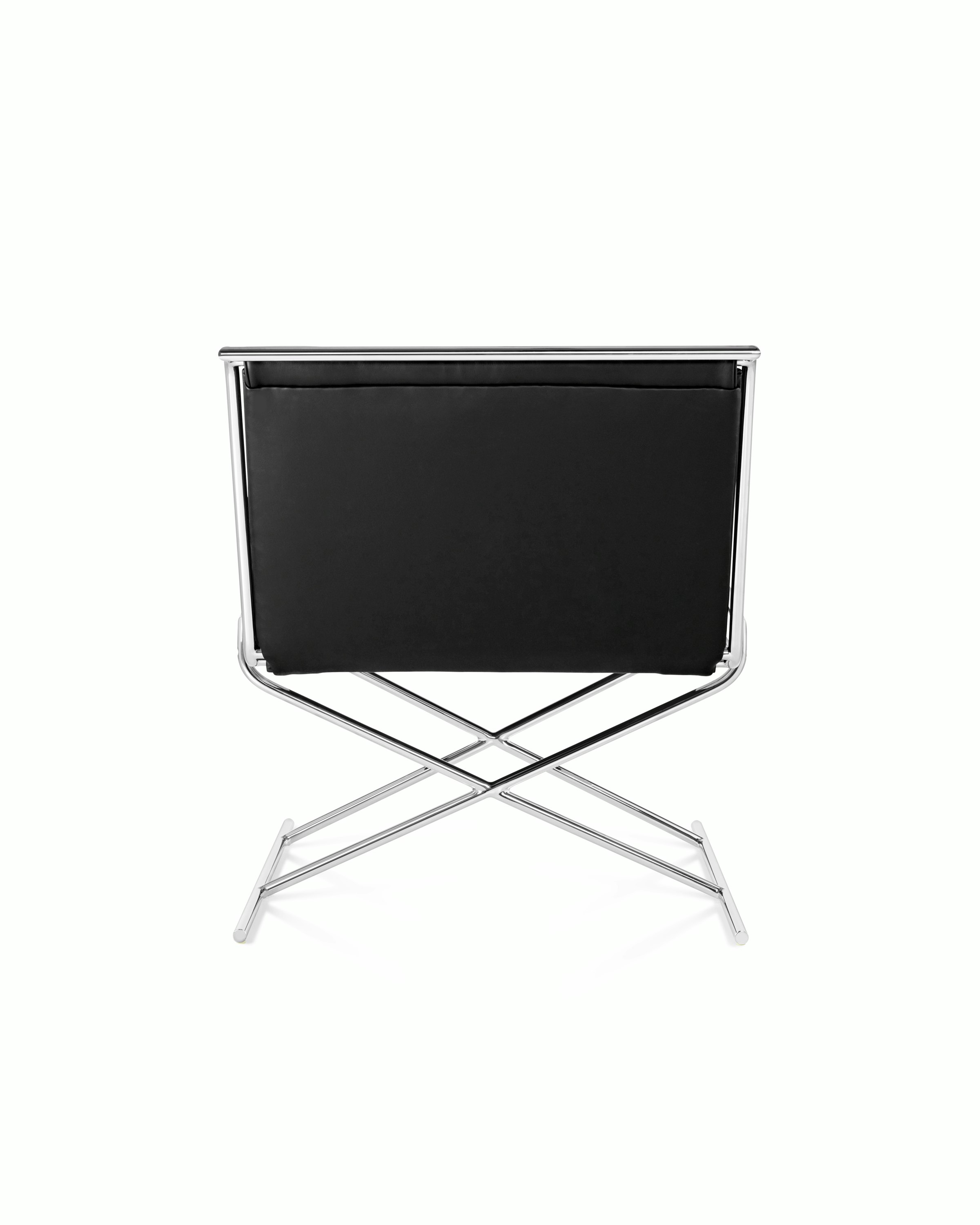 A Sled lounge chair with black leather upholstery and an X-shaped steel frame, viewed from behind.