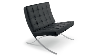A front three-quarter view of a black Knoll Barcelona Chair with a silver frame