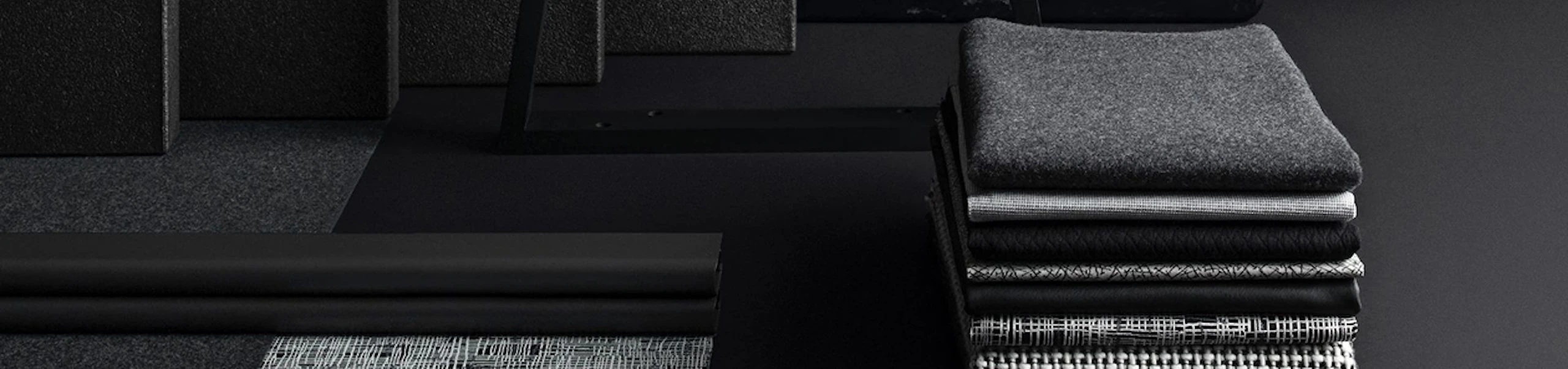 A stack of folded textile material placed neatly on the floor next to hard-finish materials.