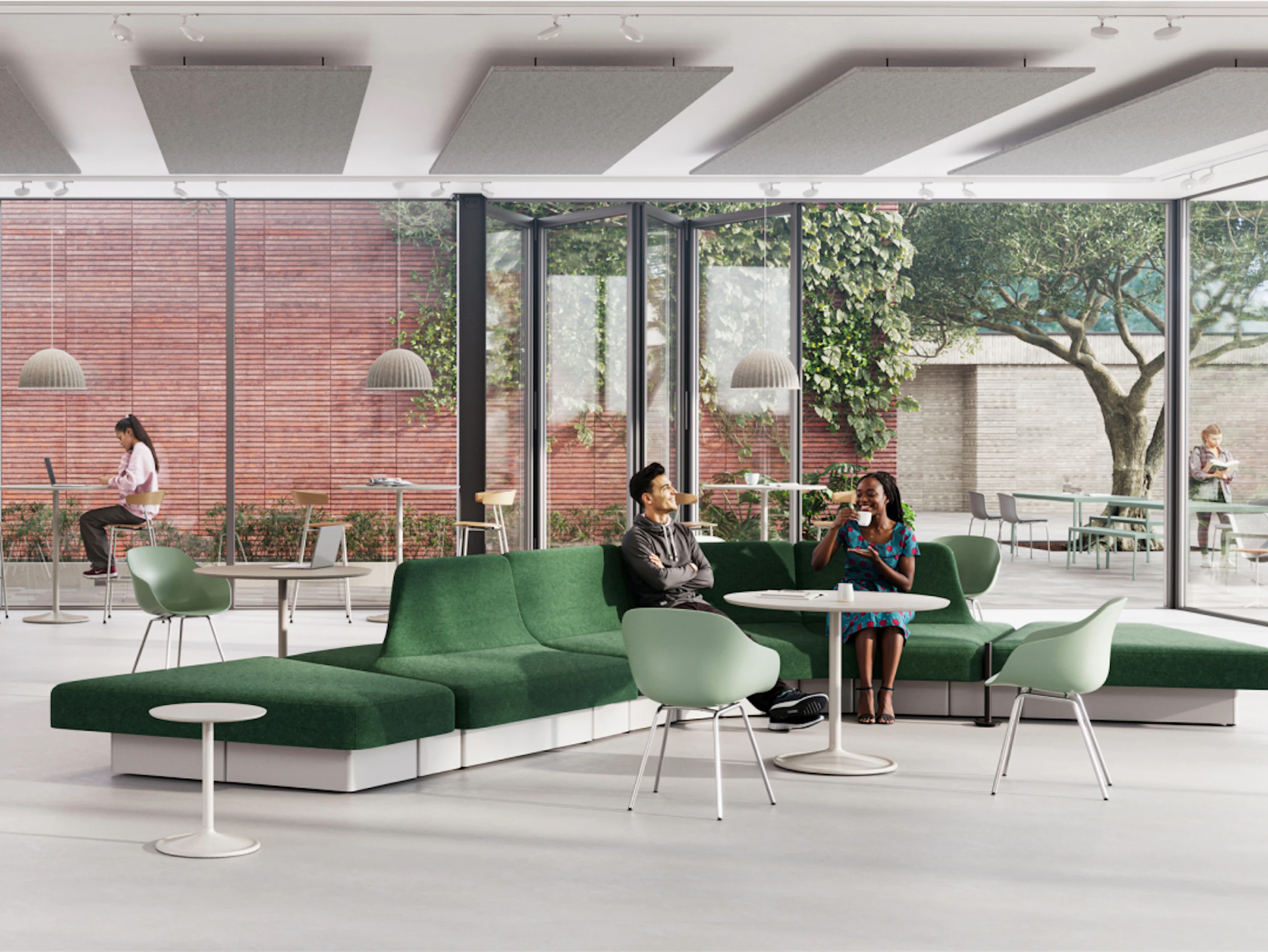 Área de estar moderna con sofá modular verde, mesas de madera clara y varias opciones de asientos. Grandes ventanales dan a un espacio verde con árboles.