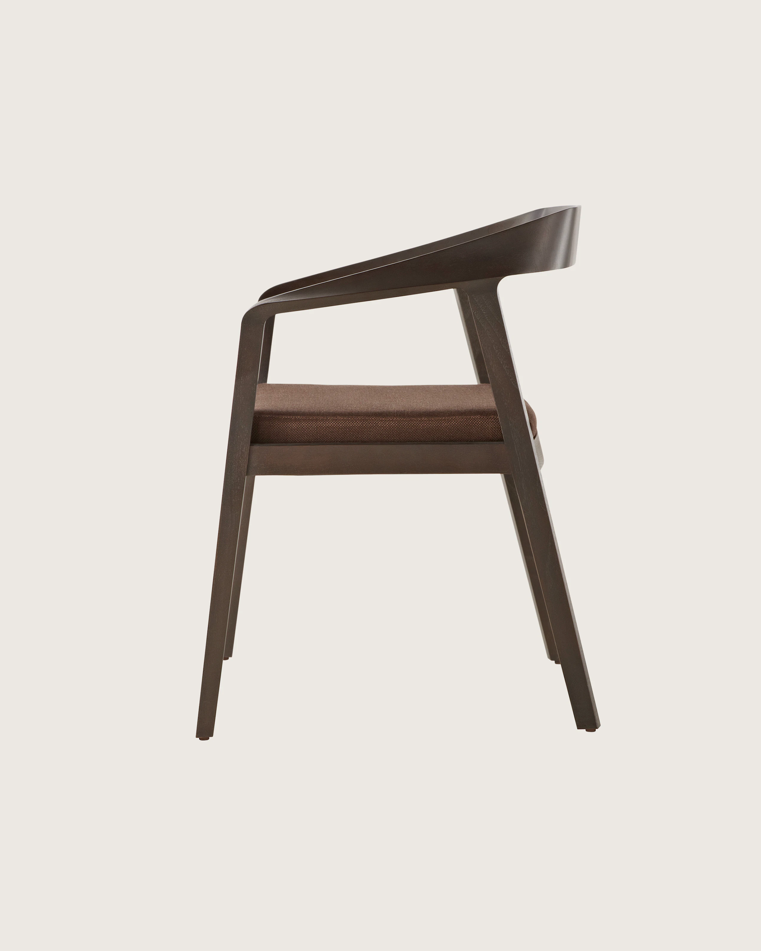 Side view of a Full Twist Guest Chair with a dark wood frame and a brown upholstered seat pad. Select to go to the Side Chairs landing page.