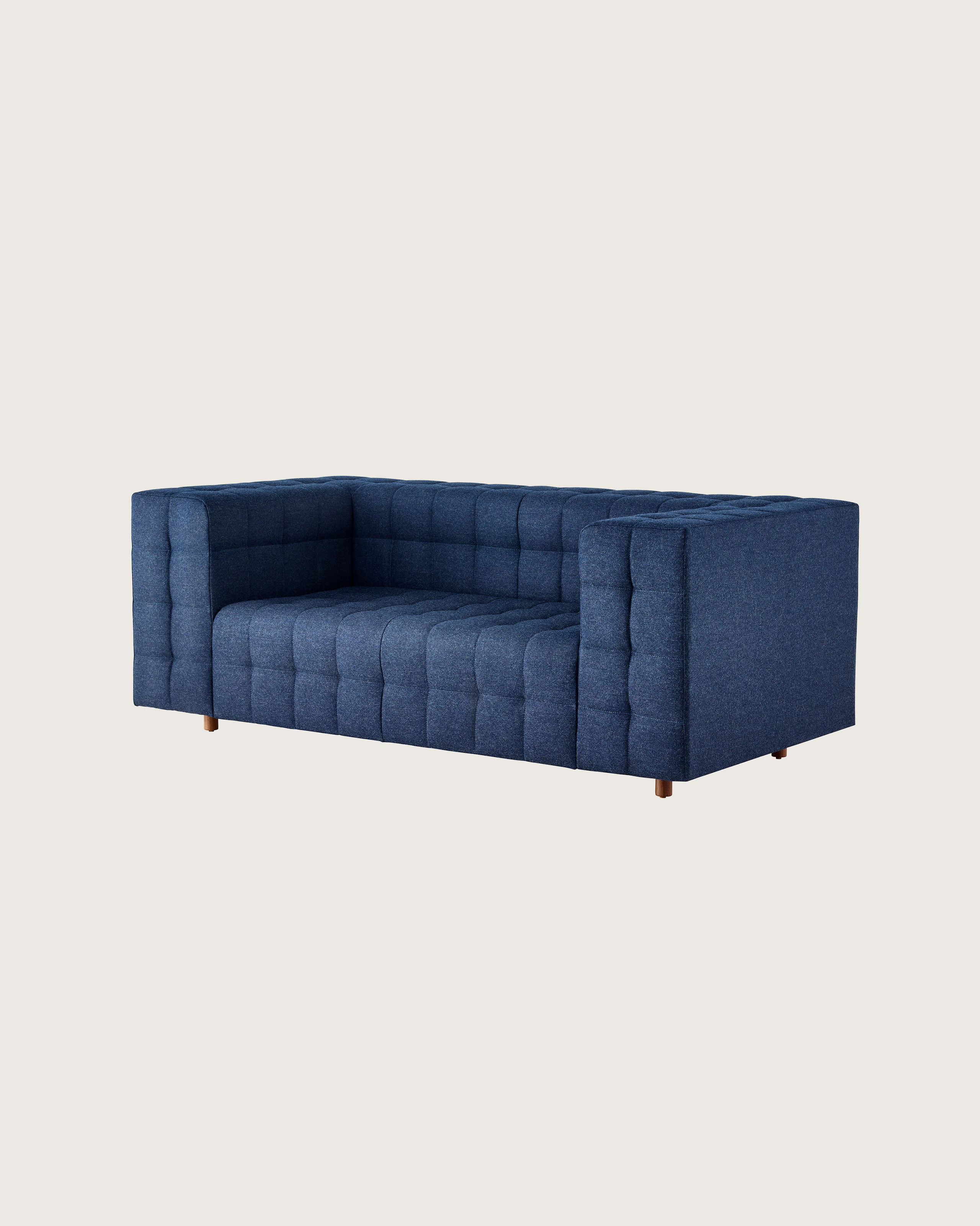 A two-seat Rapport Sofa in a deep navy colored textile, viewed at an angle.