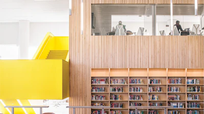 Yellow staircase with rooms above bookshelves at North Carolina State Hunt Library.