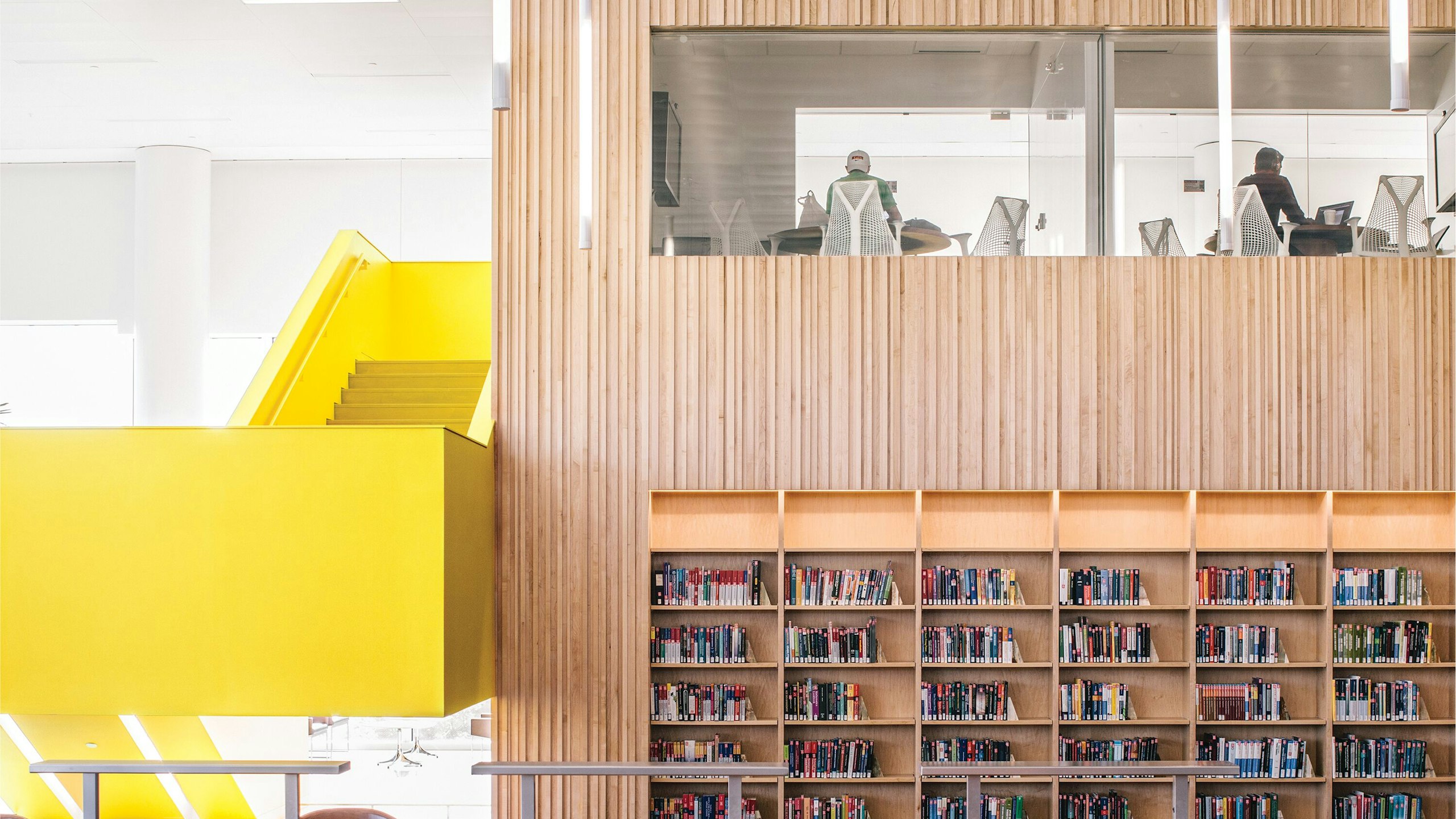Yellow staircase with rooms above bookshelves at North Carolina State Hunt Library.