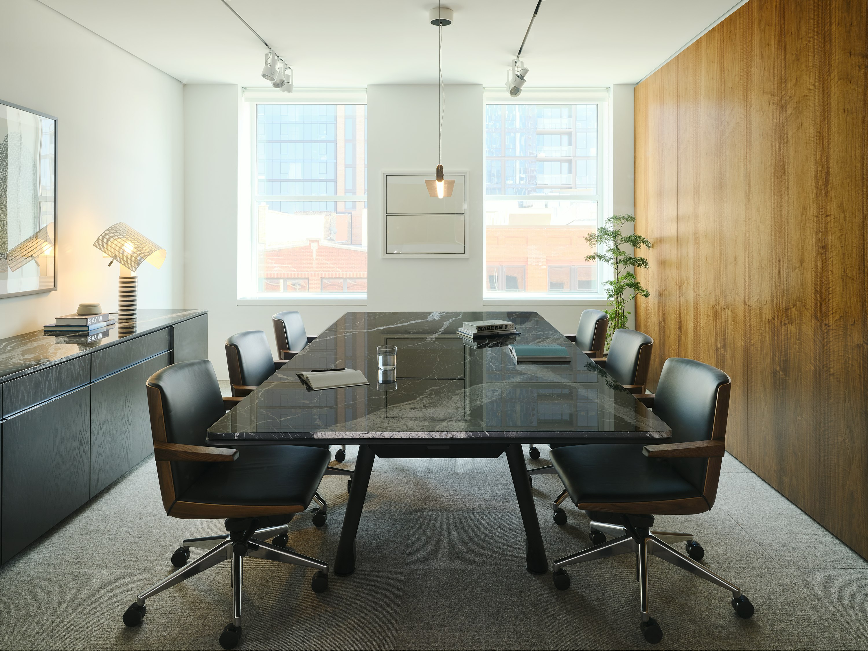 Ascent Conference Table in Nero Marquina Marble and Credenza in Ebonized Oak, both designed by EOOS, with Geiger Clamshell Conference Chairs designed by BassamFellows shown in a meeting room in the Geiger Chicago Showroom.