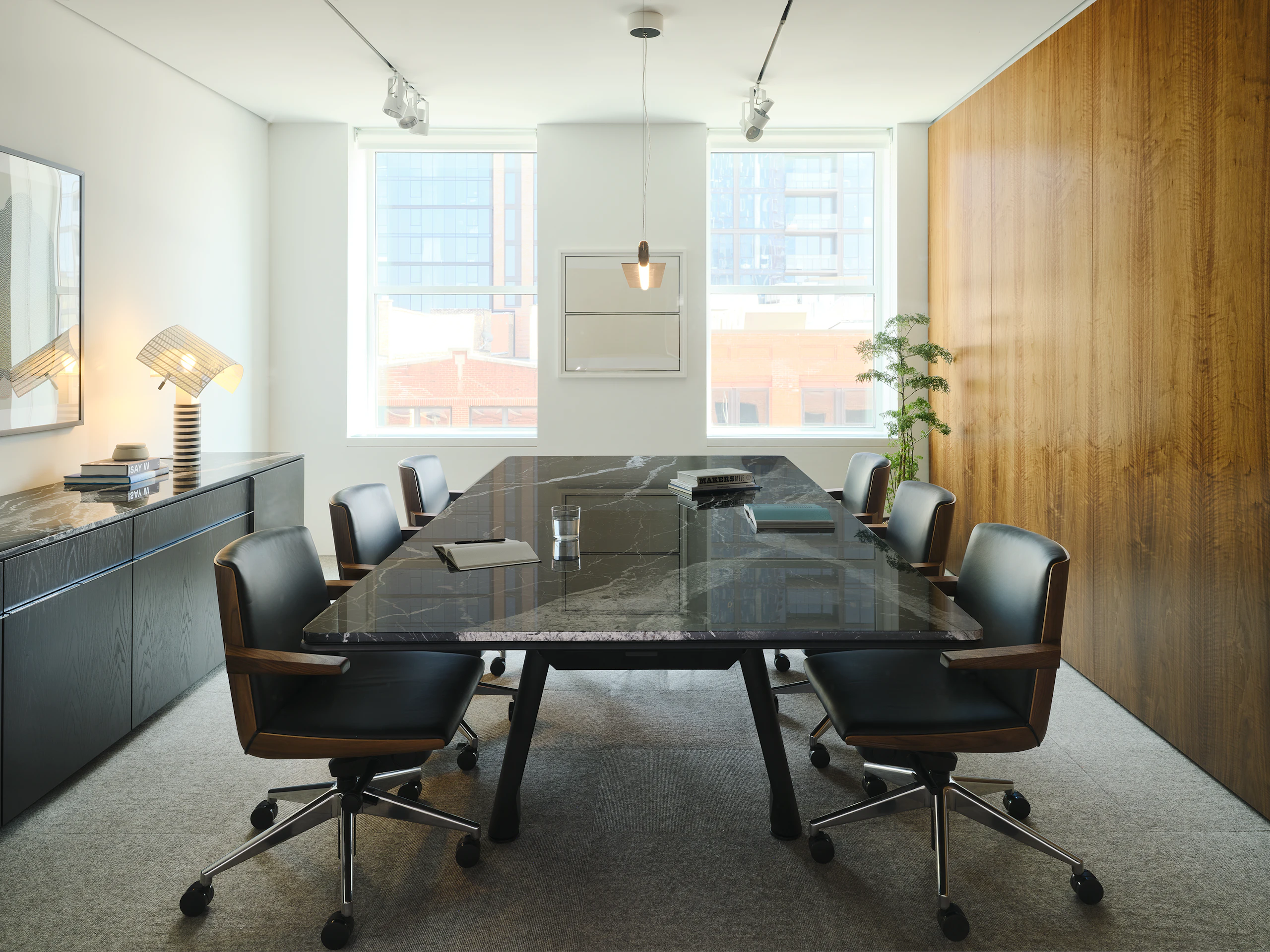 Ascent Conference Table in Nero Marquina Marble and Credenza in Ebonized Oak by DatesWeiser, both designed by EOOS, with Geiger Clamshell Chairs designed by BassamFellows shown in a meeting room in the Geiger DatesWeiser Chicago Showroom