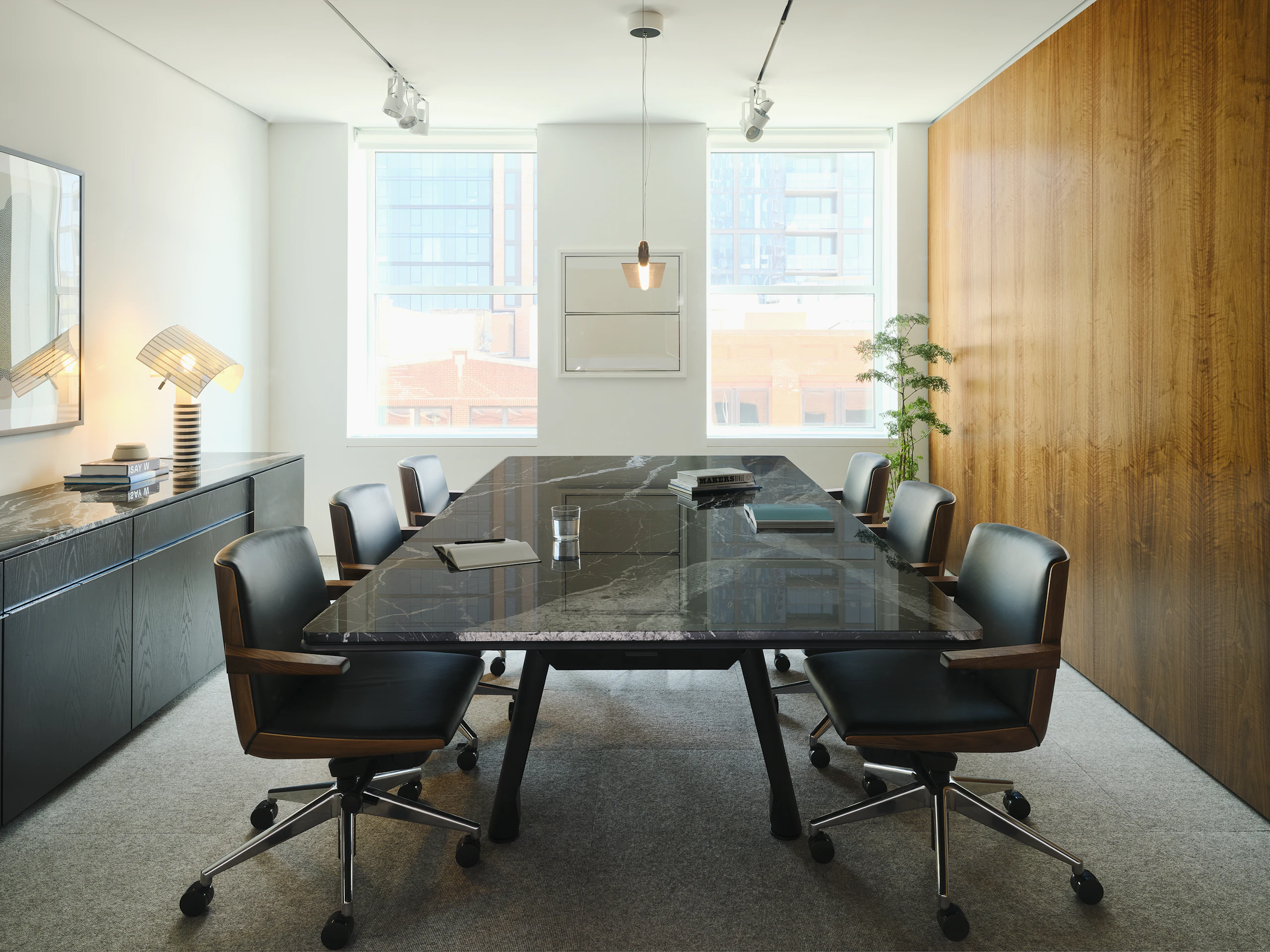 Ascent Conference Table in Nero Marquina Marble and Credenza in Ebonized Oak, both designed by EOOS, with Geiger Clamshell Conference Chairs designed by BassamFellows shown in a meeting room in the Geiger Chicago Showroom.
