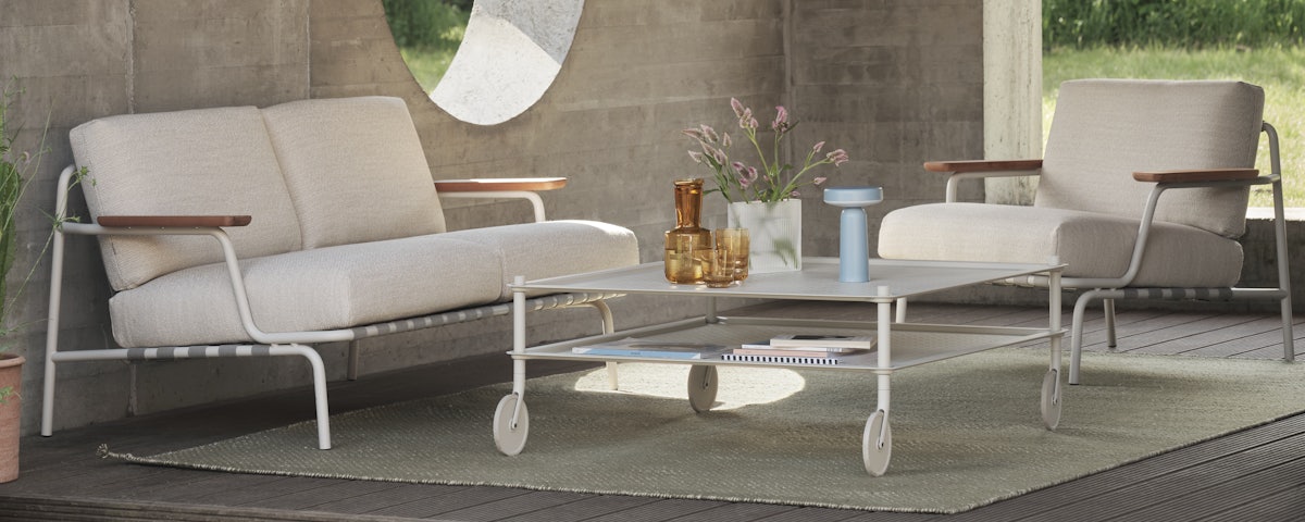Flow Coffee Table, Settle Lounge Sofa, and Settle Lounge Chair in a courtyard setting