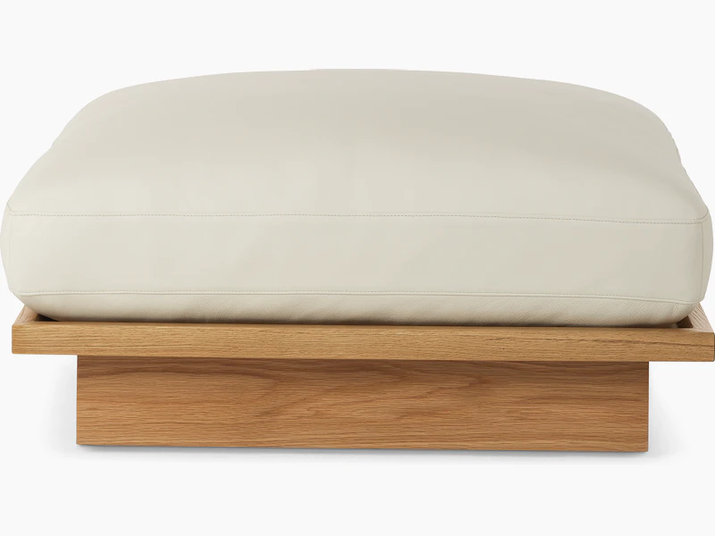 Pawson Drift Ottoman with white leather upholstery and white oak base, viewed from the front.