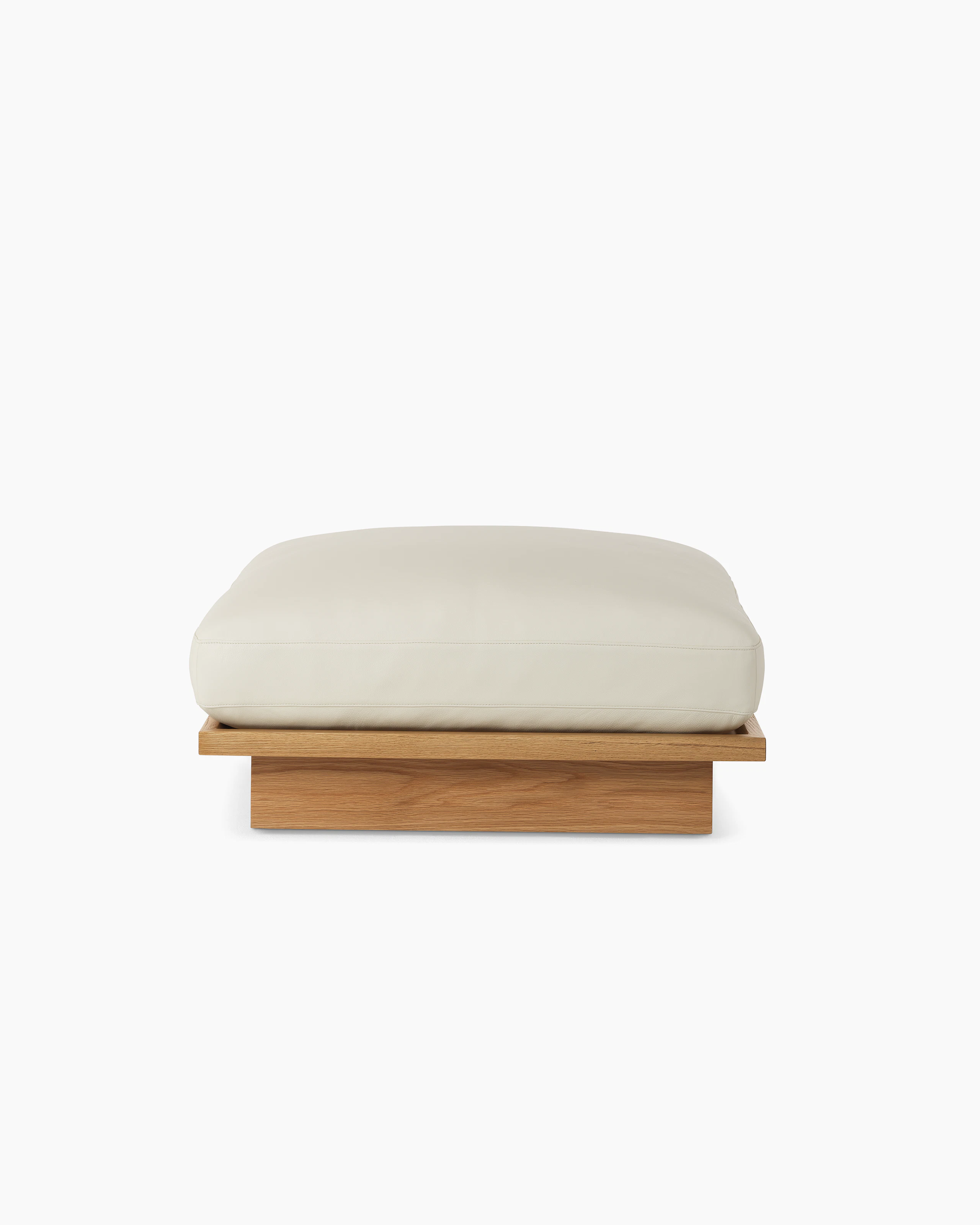 Pawson Drift Ottoman with white leather upholstery and white oak base, viewed from the front.